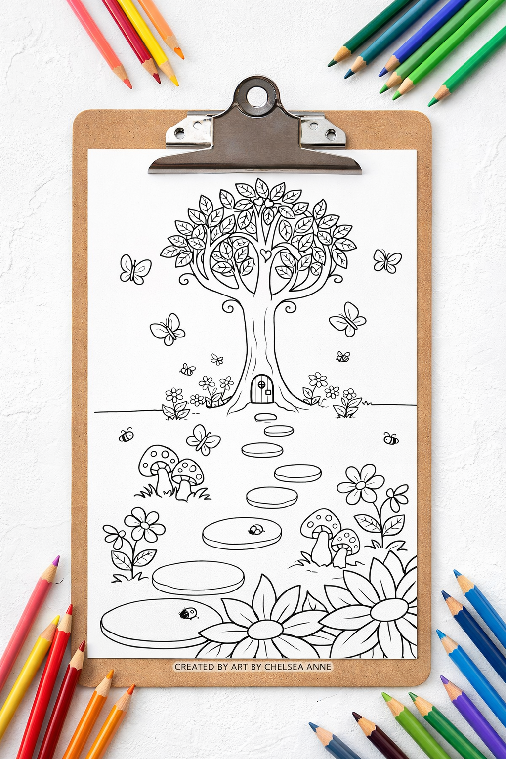 Black and white coloring page of a whimsical tree with a door at its base, surrounded by butterflies, flowers, and mushrooms, on a clipboard with colored pencils around it.