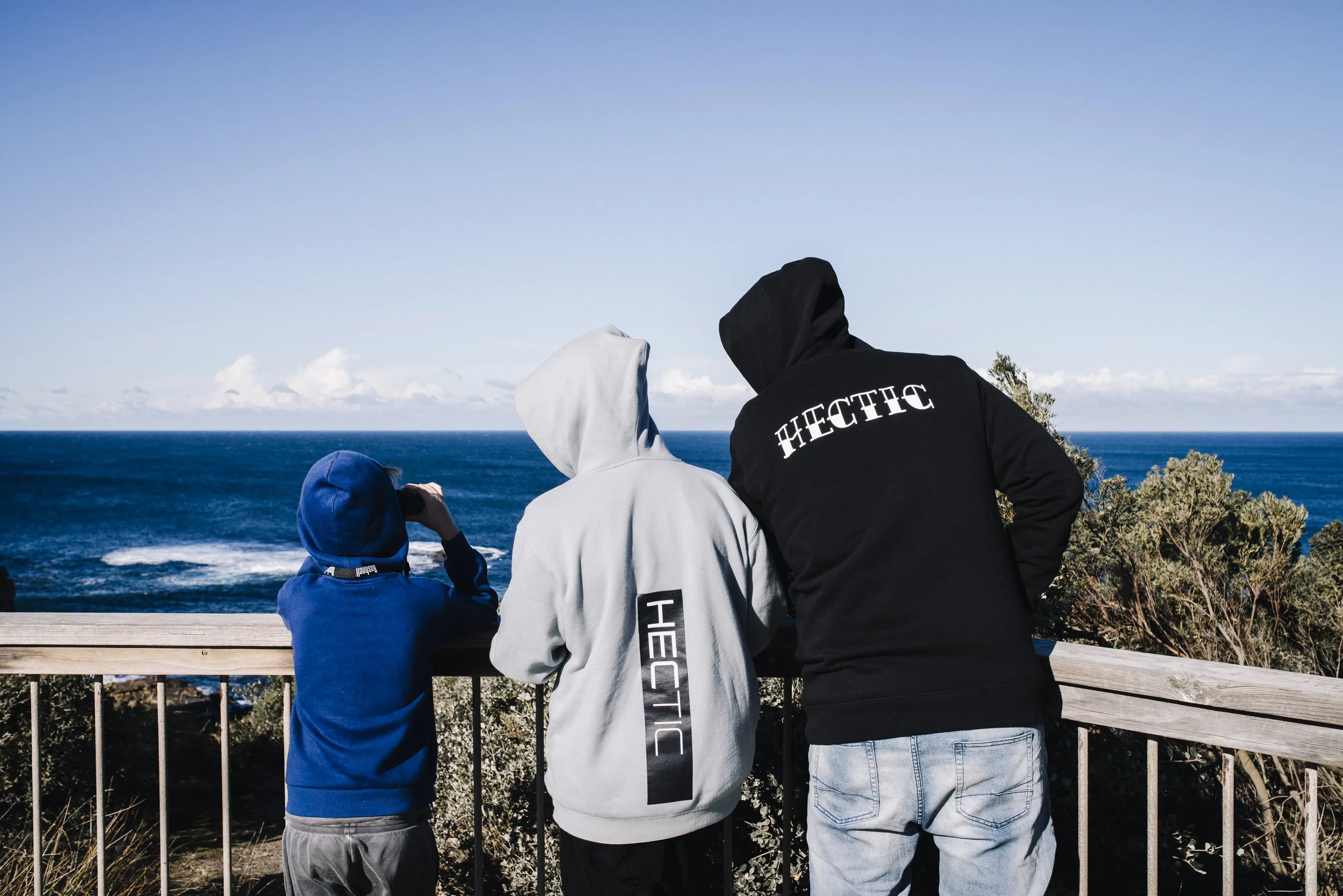 Family by the coast looking for whale wearing Hectic Clothing Australia Hoodies