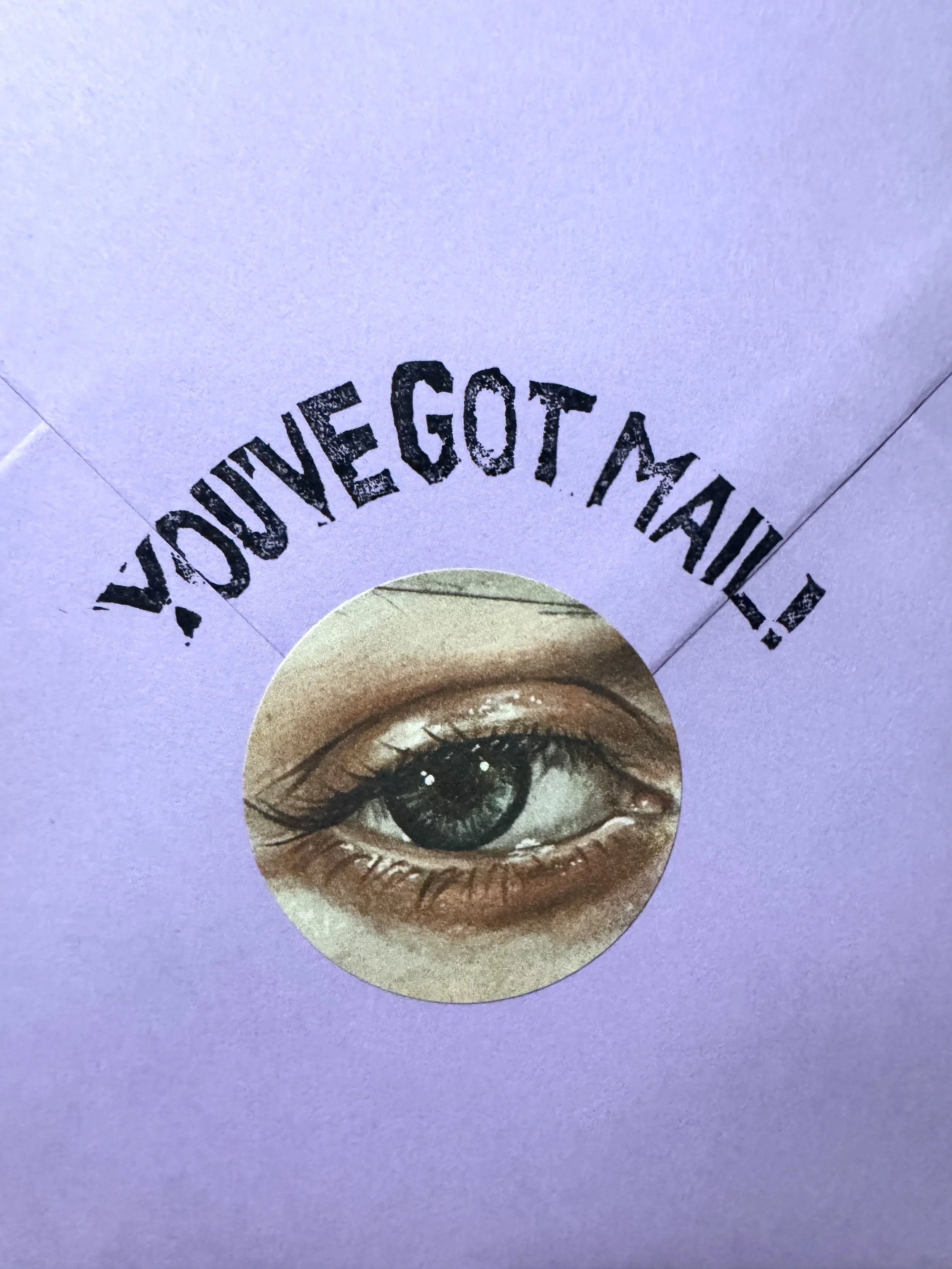 A sticker with a realistic illustration of a human eye on a purple background. The sticker contains the text 'YOU'VE GOT MA' arching above the eye.