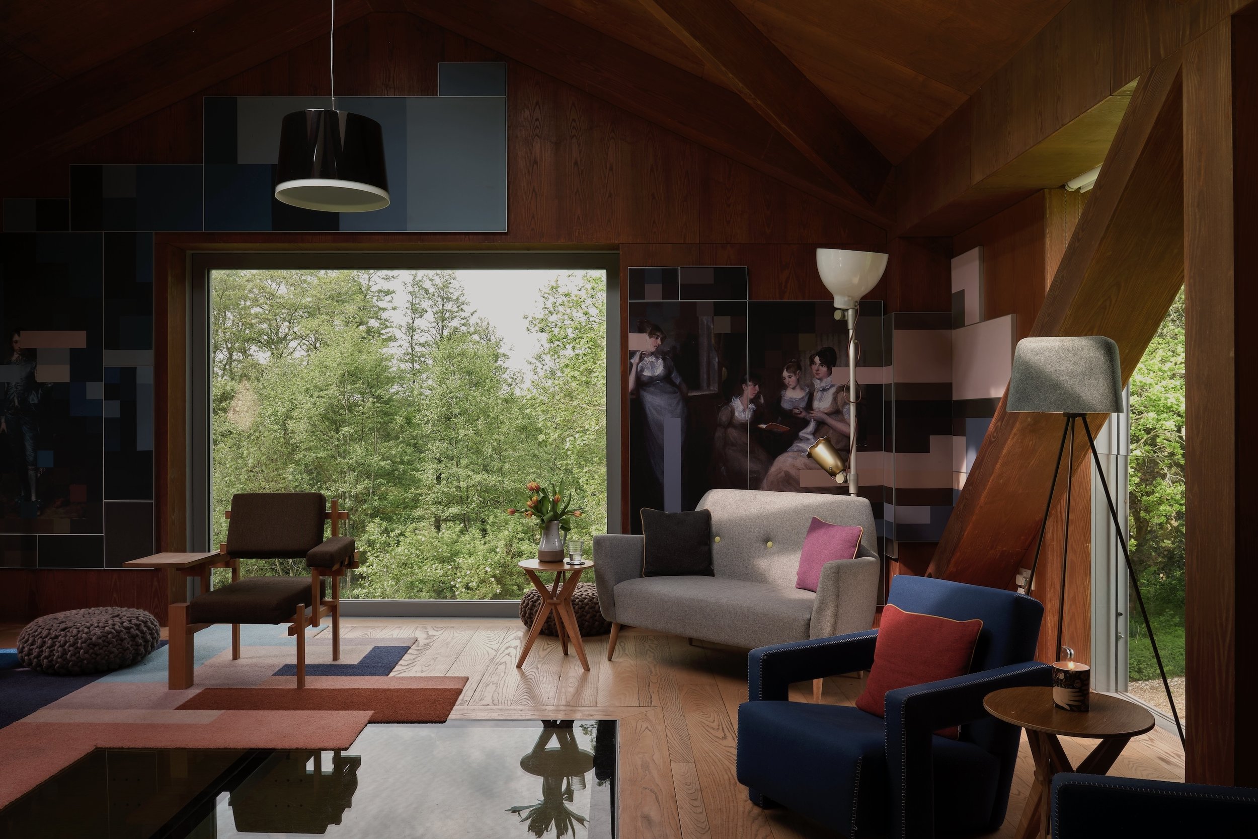 Modernist living room with wood panelled walls, modernist furniture and views to the garden