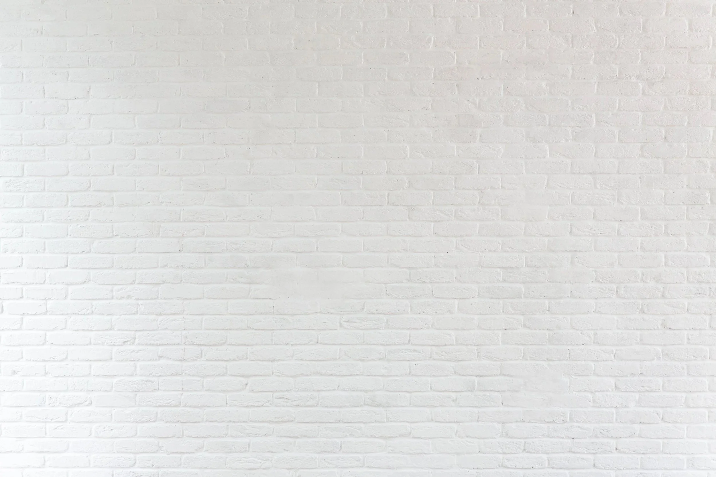 A white brick wall with an even pattern and no objects or decorations.