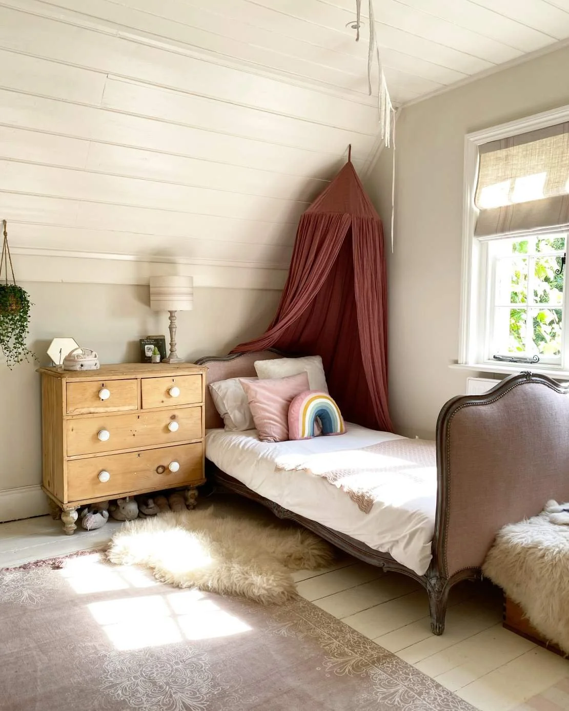 A cozy bedroom with a bed, nightstand, and window, decorated in soft pastel tones and bohemian style.