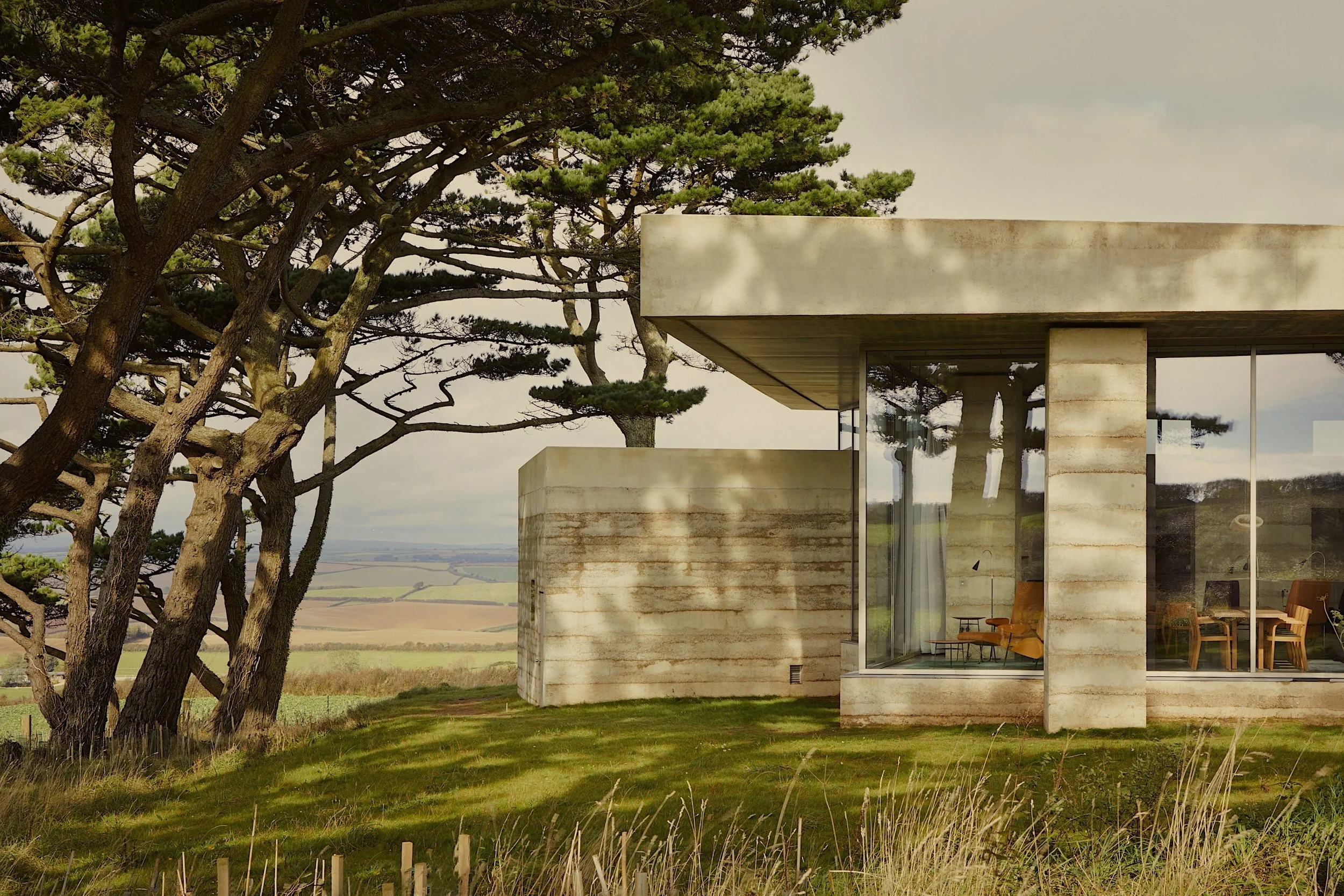 Modernist living room with wood panelled walls, modernist furniture and views to the garden