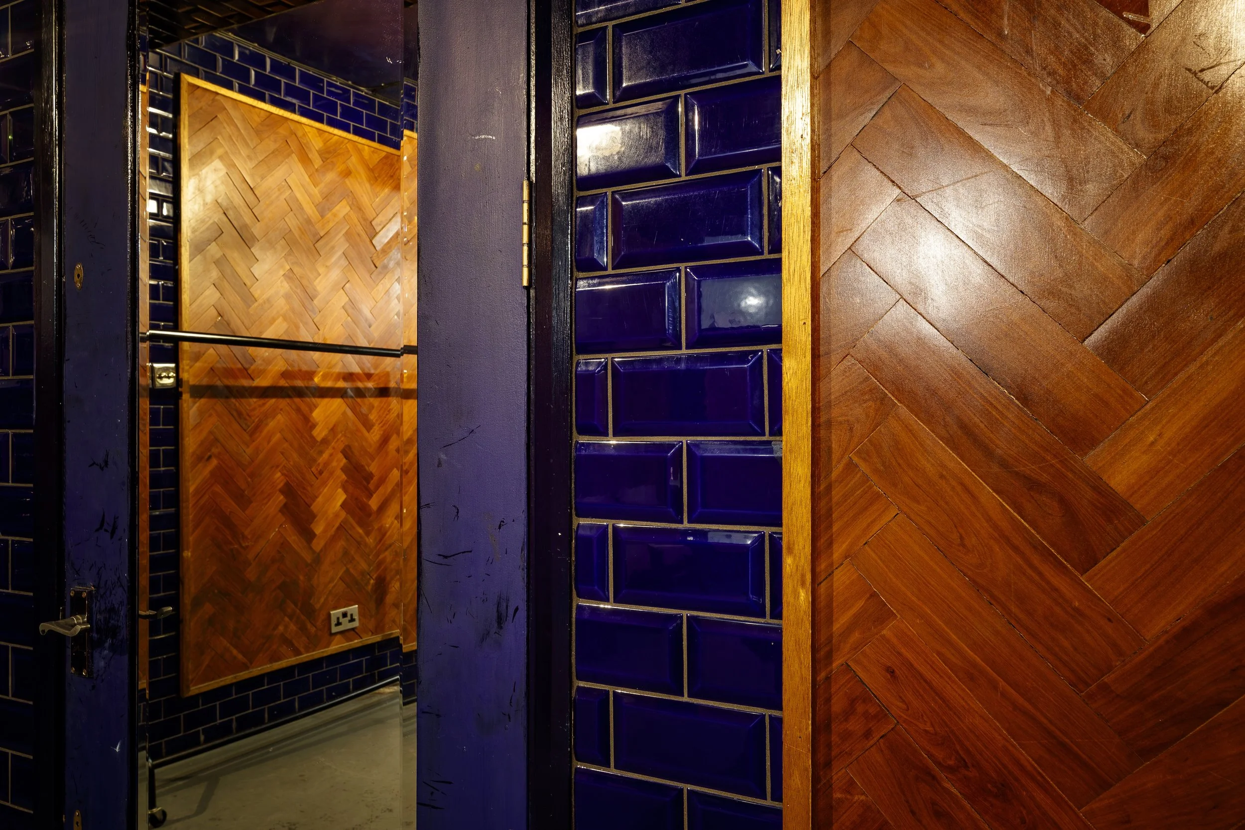 Interior view of a room with wood and tile wall decor, mirror, and a handrail.
