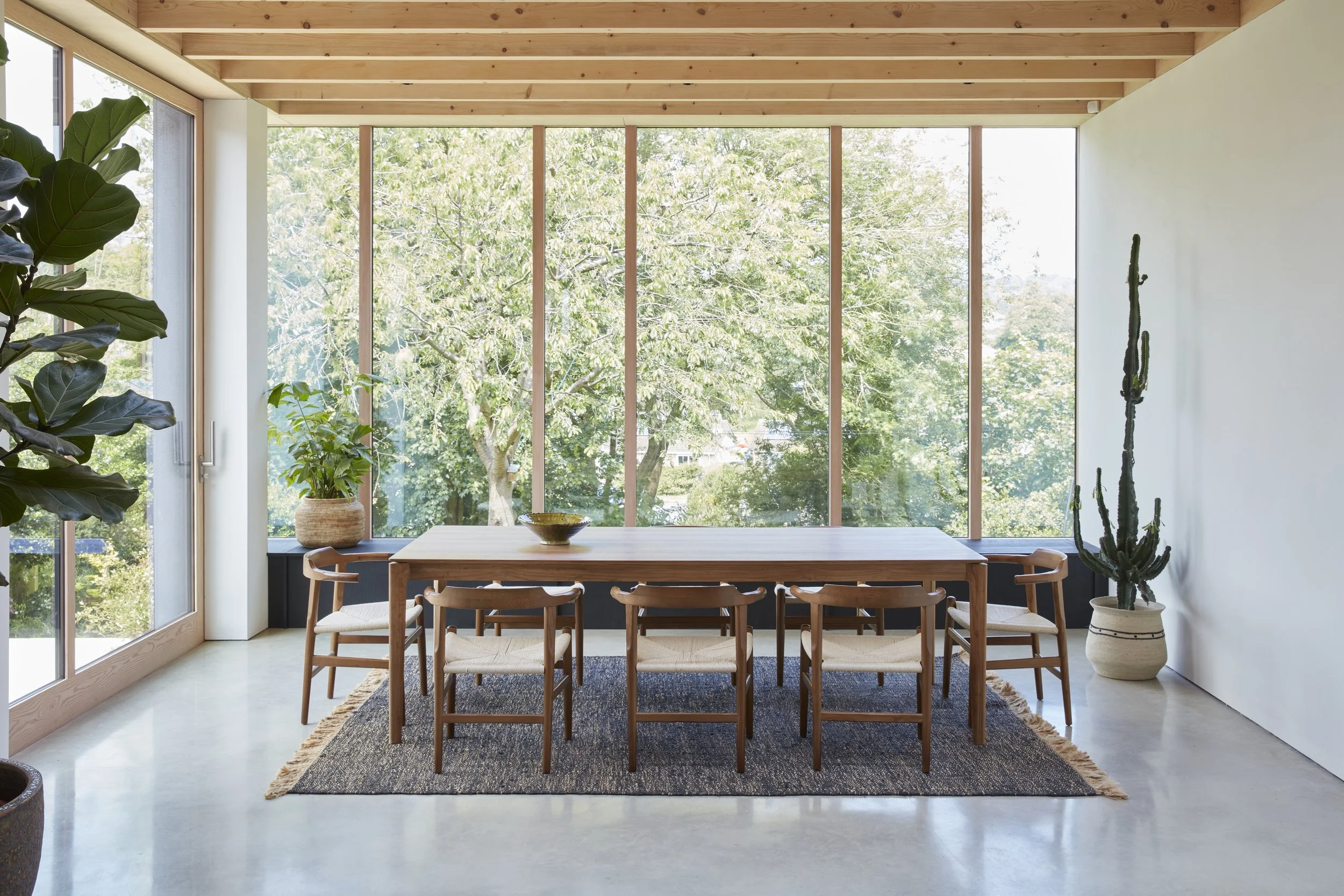 Full length glass windows and dining table in a minimal house