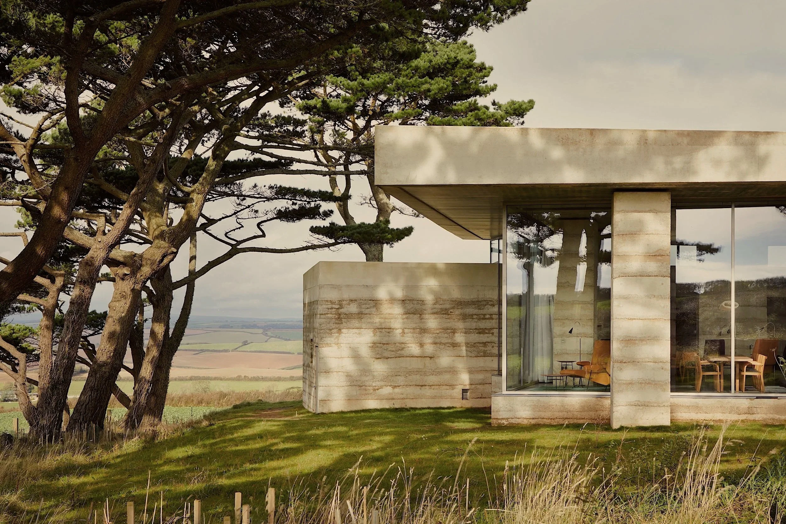 Modernist living room with wood panelled walls, modernist furniture and views to the garden