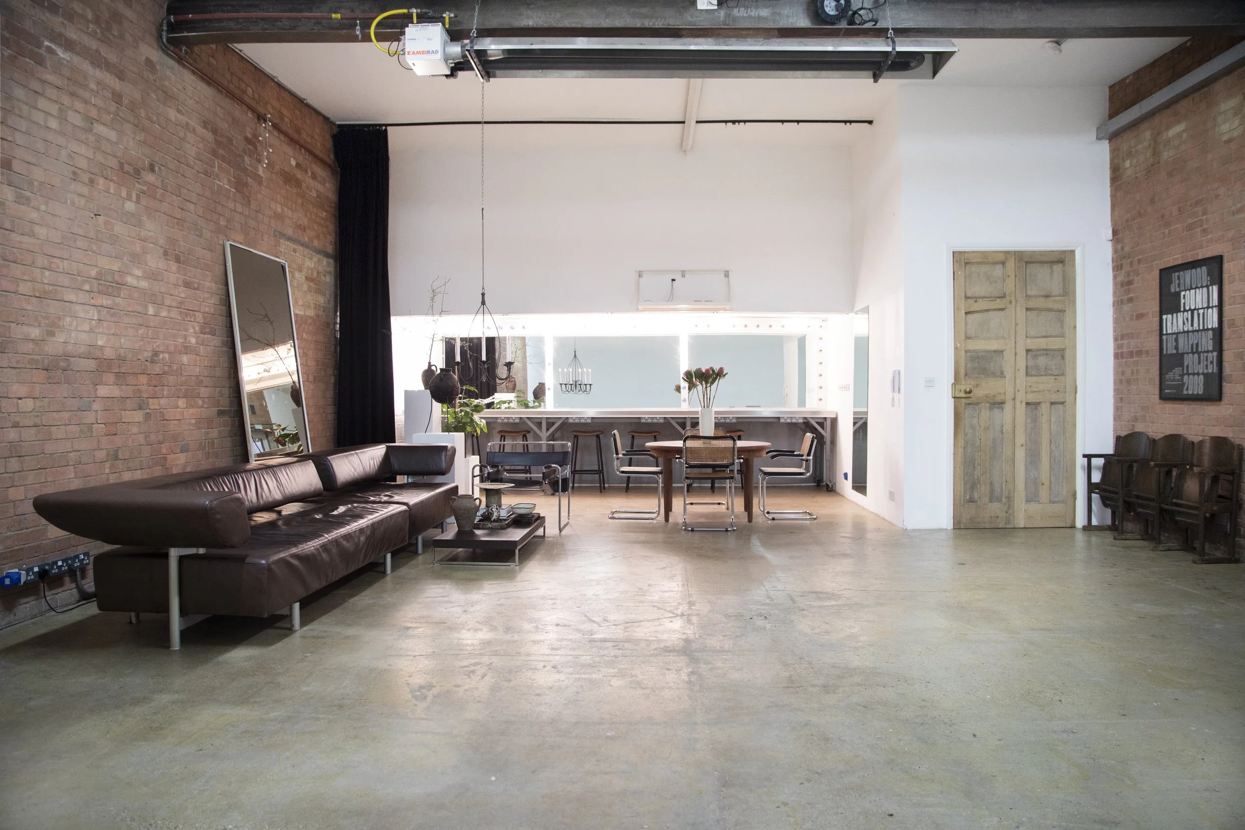 Warehouse photography studio with vintage furniture, concrete floor and exposed brick walls