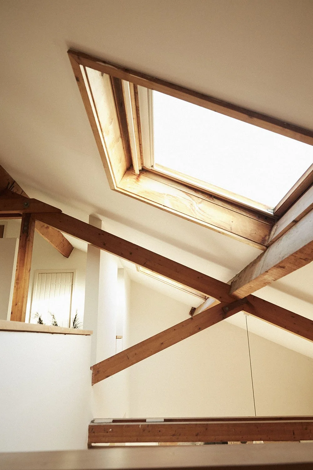 Interior view of a room with a wooden ceiling and a skylight window allowing natural light inside.
