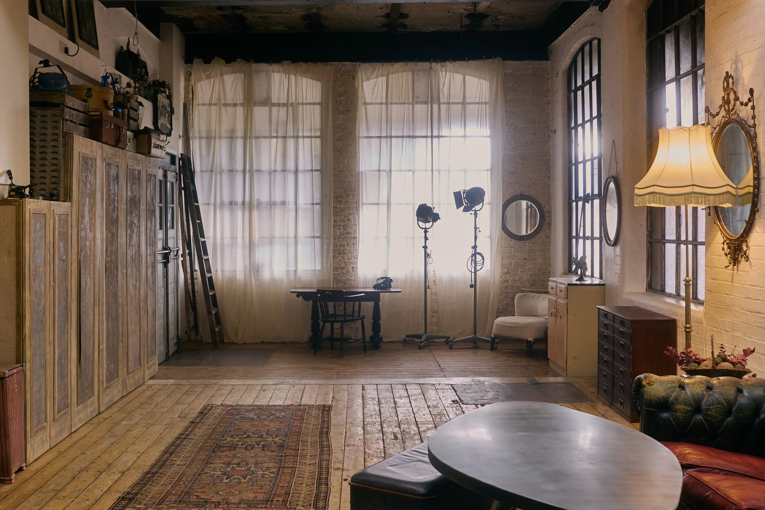 Vintage furniture and wooden flooring in a warehouse studio in North London