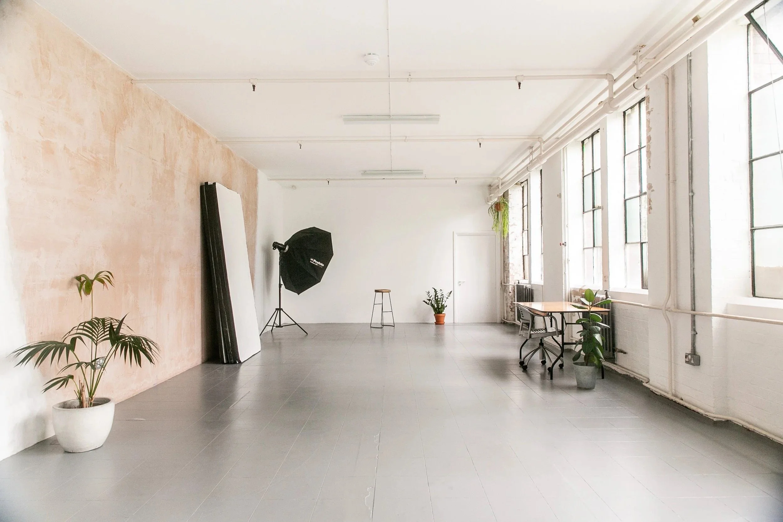 Warehouse photography studio with raw plaster and white brick walls and daylight, South London