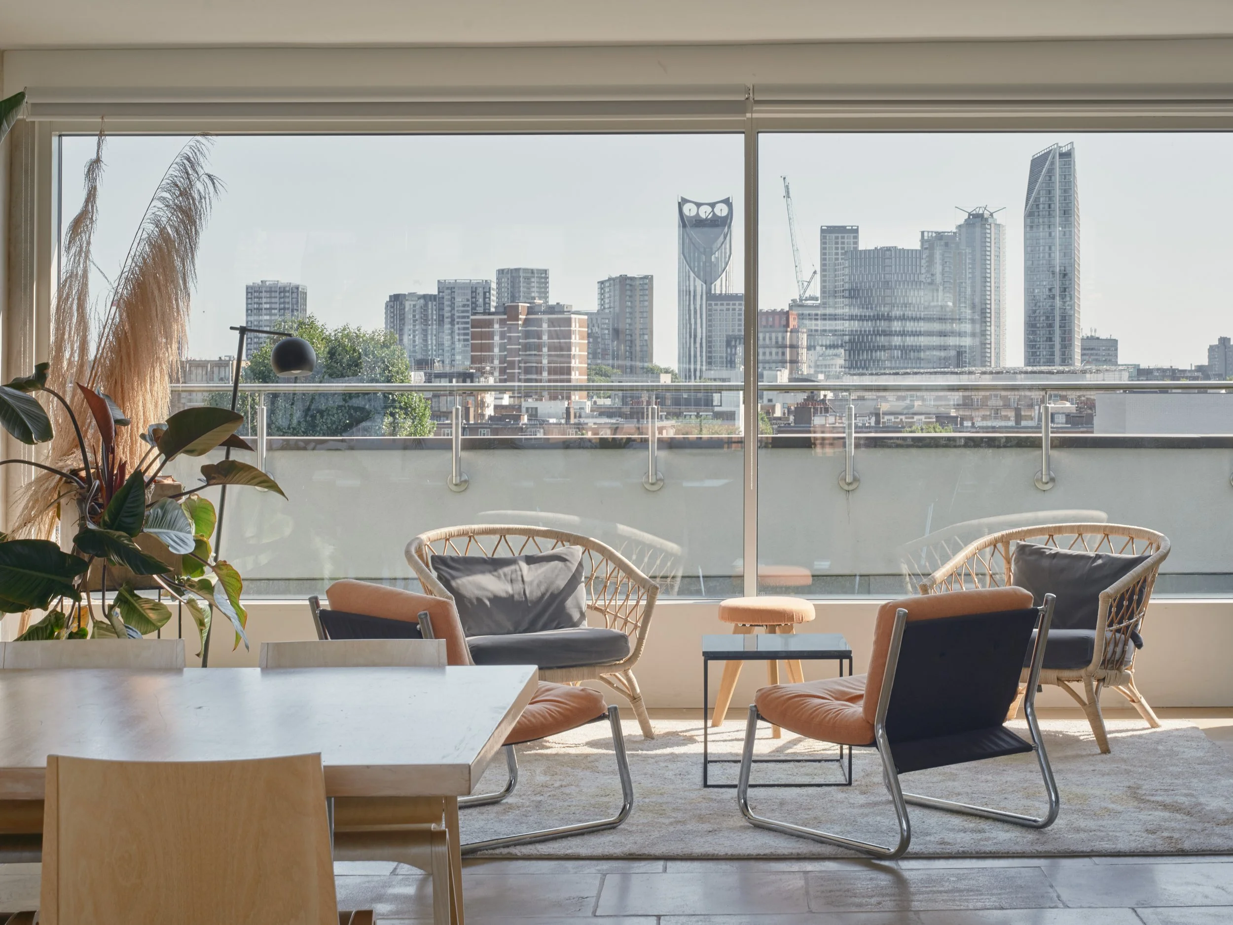 Living room with modern furniture and large windows overlooking a city skyline.