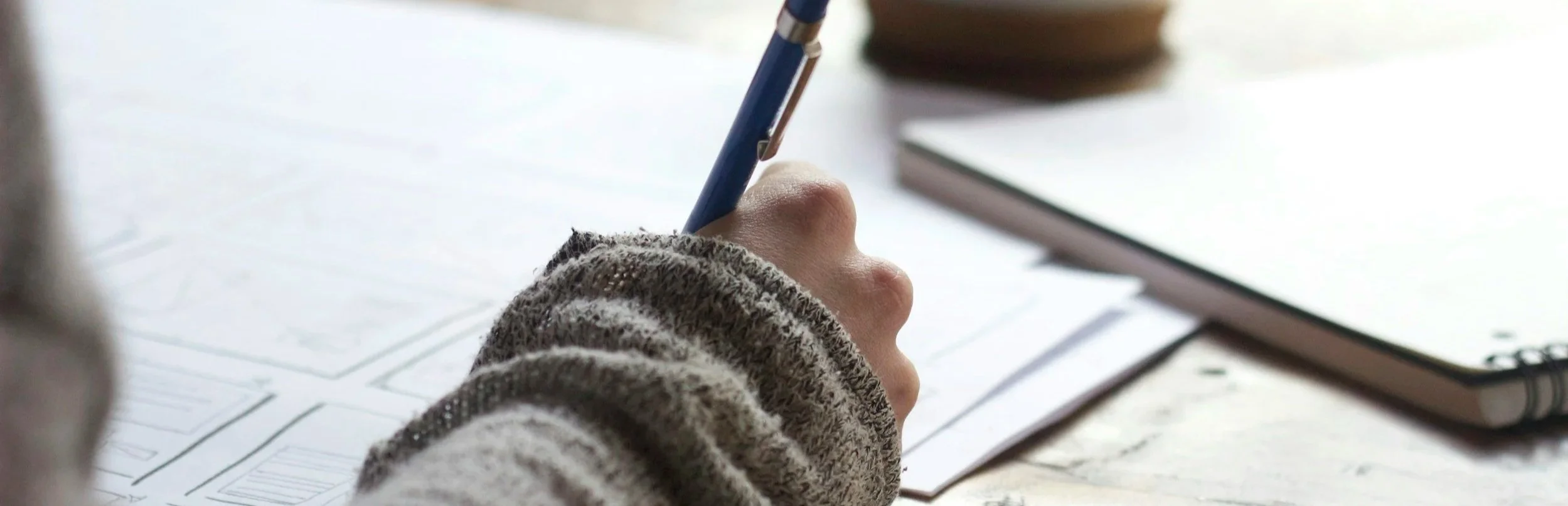 Hand writing notes during planning for a case study or testimonial video shoot