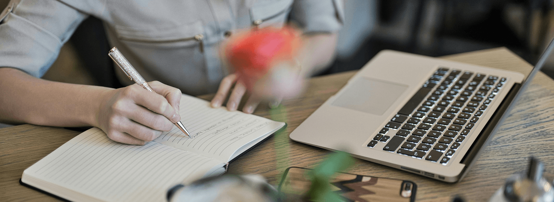 Notebook and laptop used while planning a video production brief