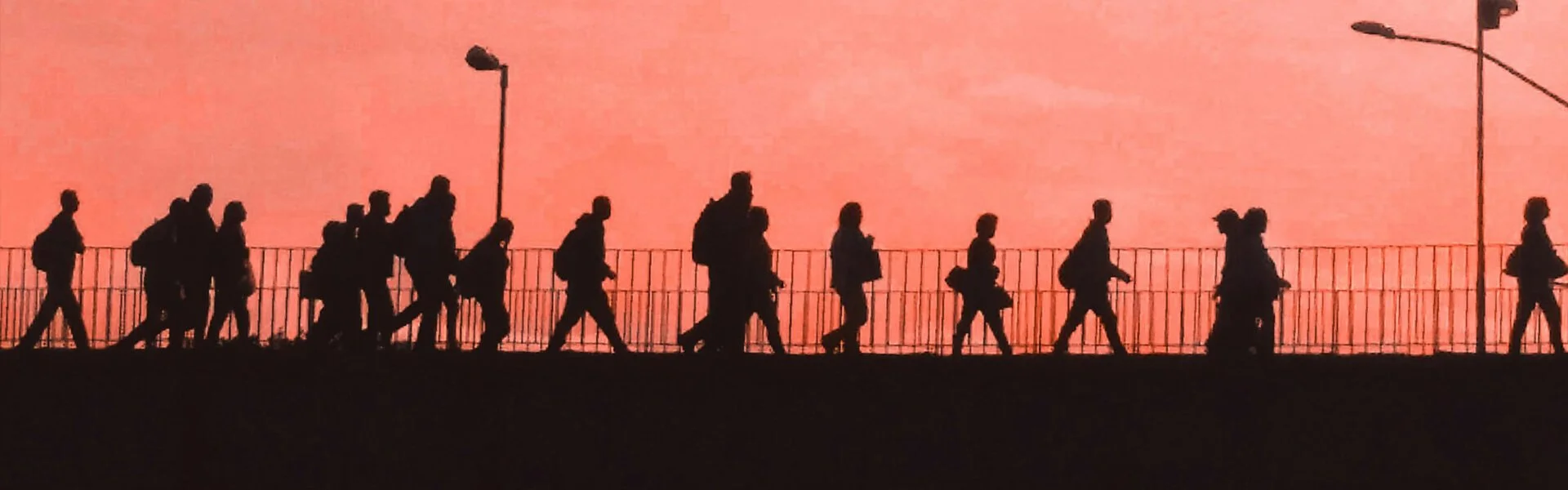 Artistic silhouette image of a mixed group of pedestrians crossing a bridge at dusk, illustrating the range of demographics, backgrounds, and daily lives that form a marketing target audience