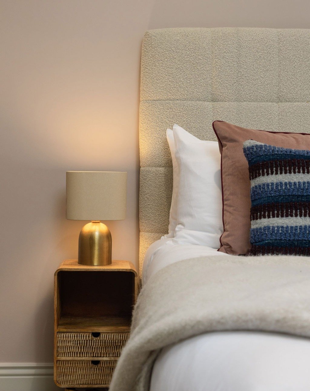 GUEST ROOM

A quiet corner that captures the essence of understated luxury. Set against softly muted China Clay walls, the textural interplay between the boucl&eacute; upholstered headboard, bespoke velour and woven cushions and brushed brass brings 
