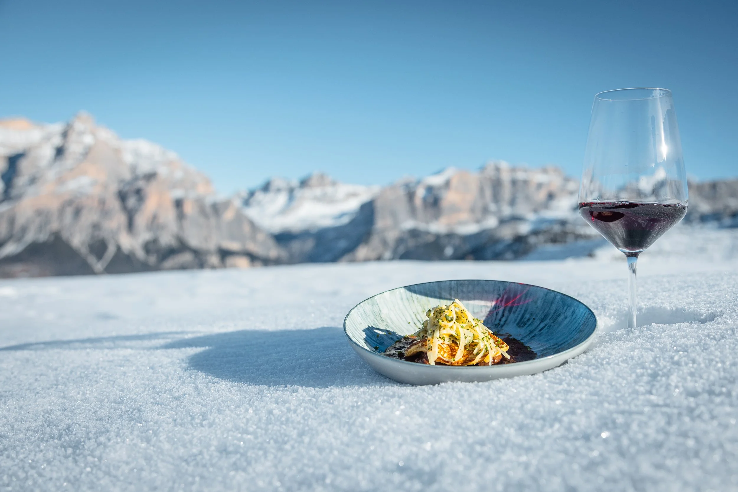 Crepe and glass of red wine framed by UNESCO World Heritage Dolomites Mountains