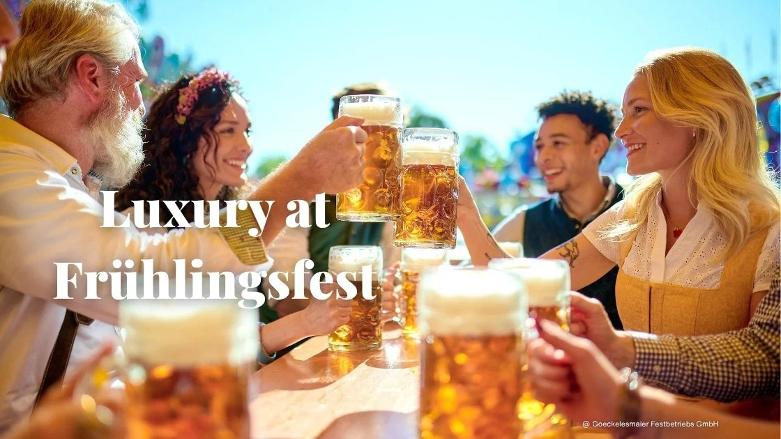 A family smiles as they toast large Maß beers in the sun at the Spring Beer Festival in Stuttgart