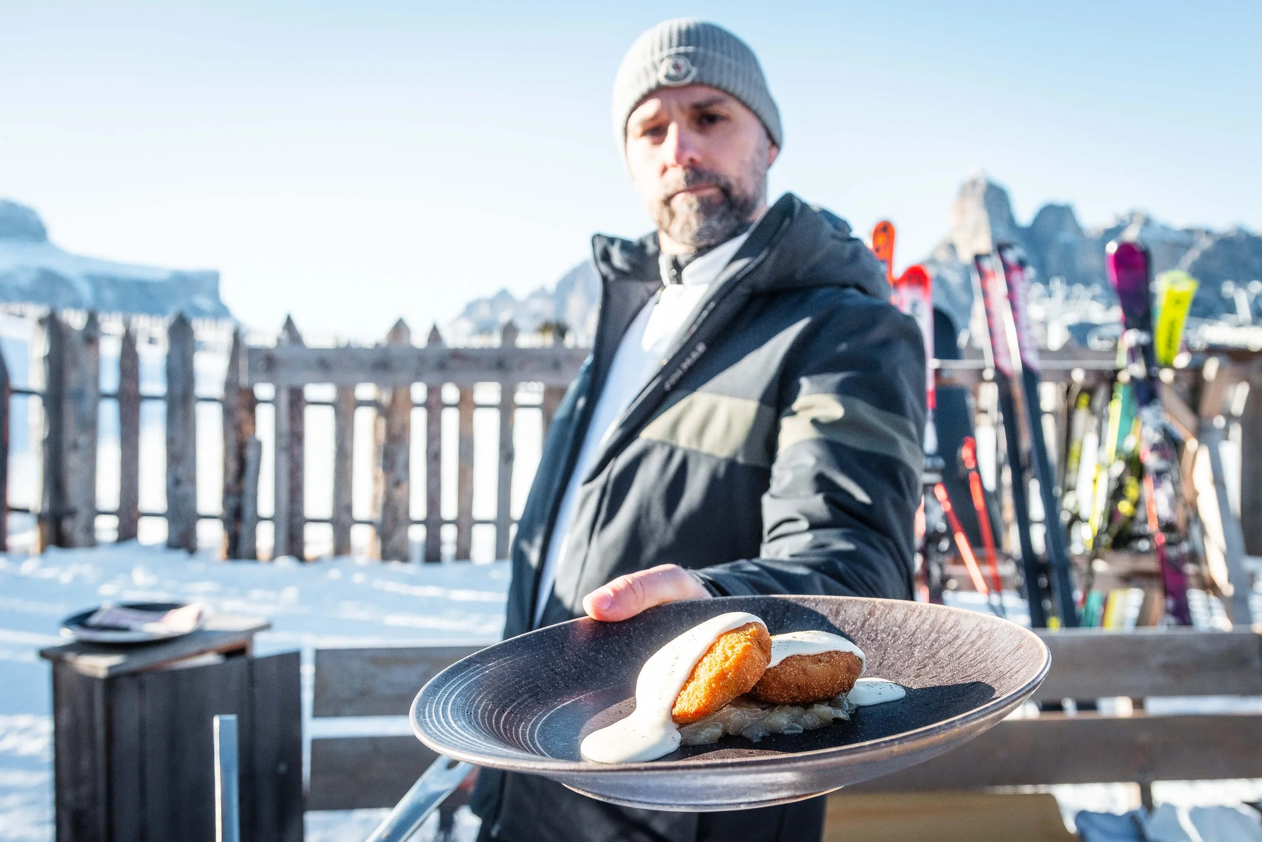 Chef offering Michelin plate with Alta Badia mountains in the background