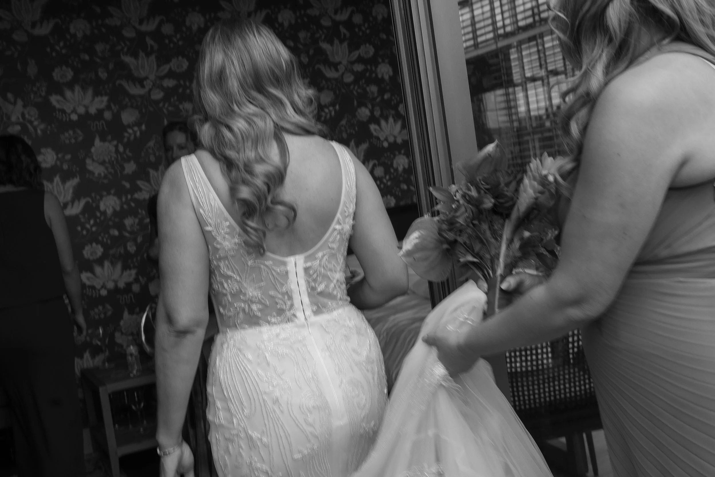 Bridal women preparing for a wedding, one holding a bouquet of flowers.