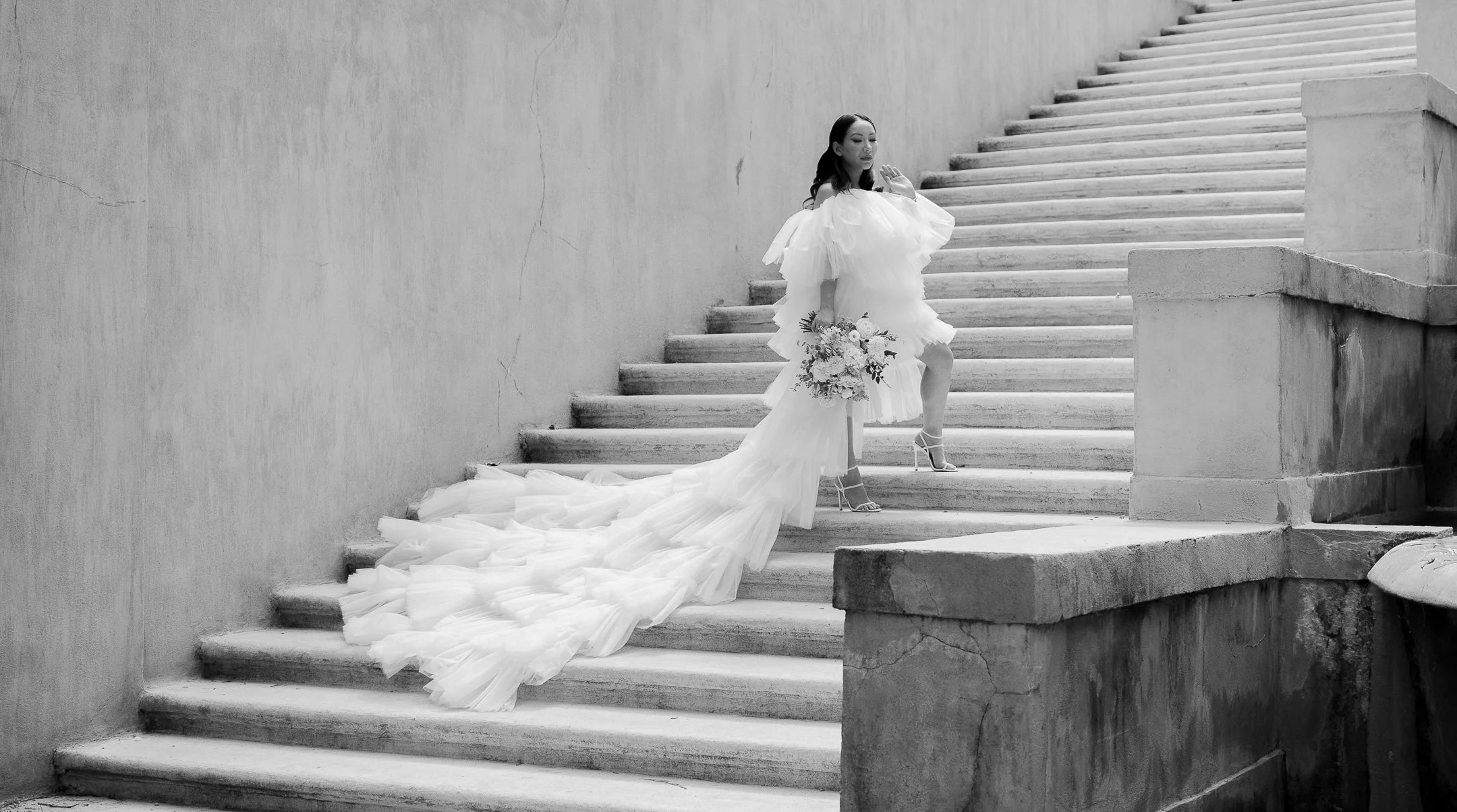 Bride in flowing dress on stairs