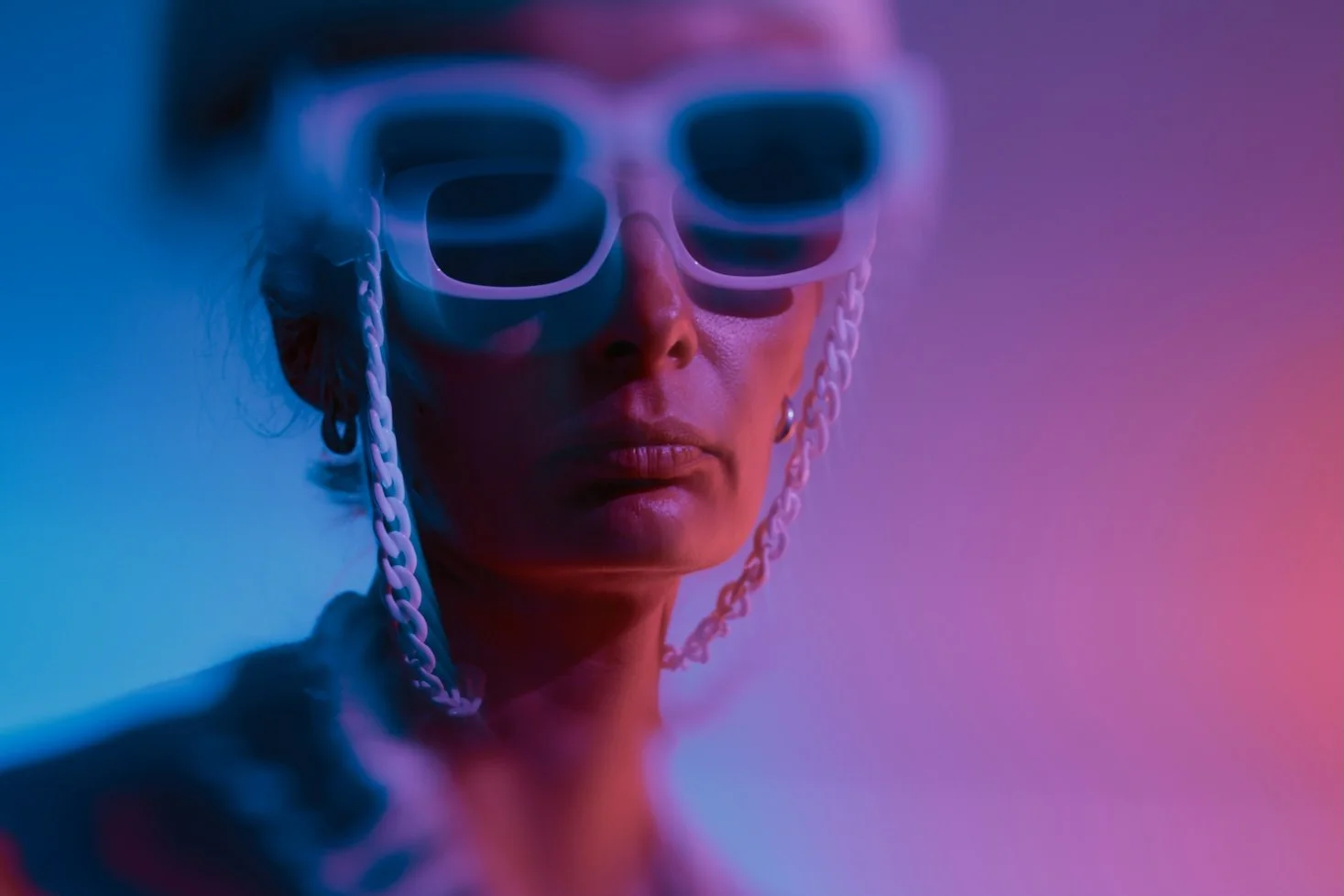 A woman with white rimmed sunglasses looking stern into the camera.