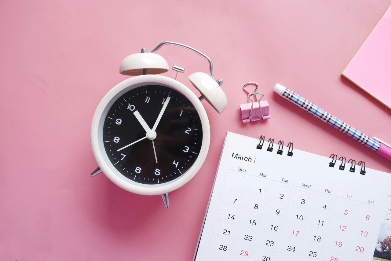 alarmclock and calendar on a pink background