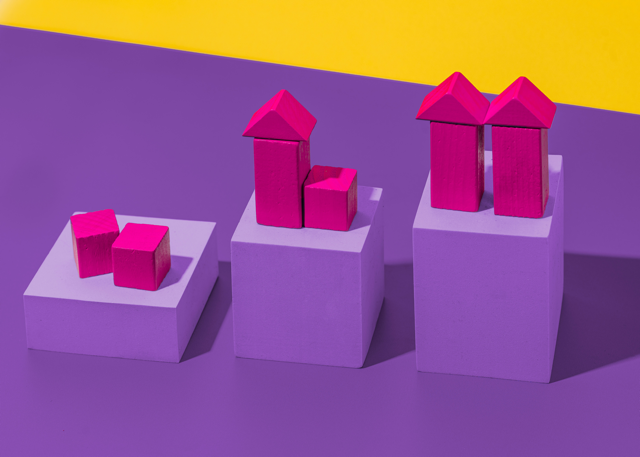 Three levels of pink building blocks indicating growth with a purple and yellow background.