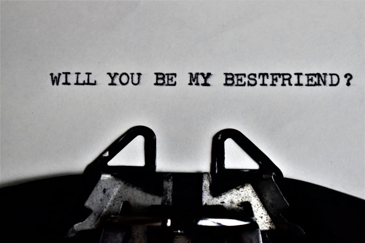 Black and white image of a typewriter spelling "Will you be my best friend" on a piece of white paper.