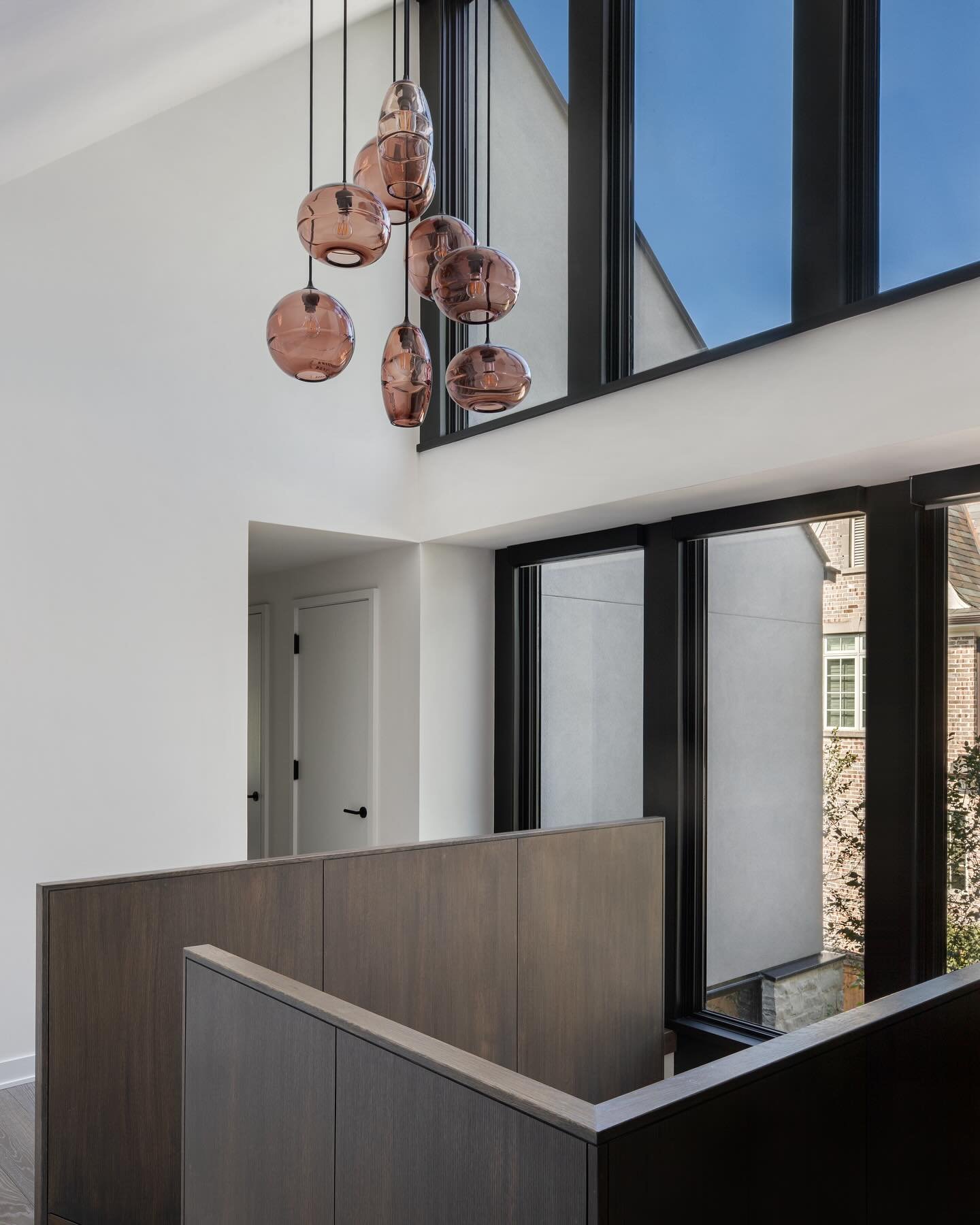 Light Well / A light well opens every level of this modern Glencoe home to natural light. Here, at the second floor landing, two stories of glass let light and views of the sky stream in. Vaulted ceilings are a consistent feature through this home bu