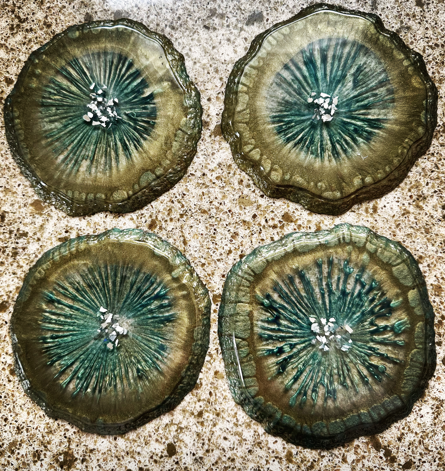 Epoxy resin art with metallic golds and teals in starburst pattern