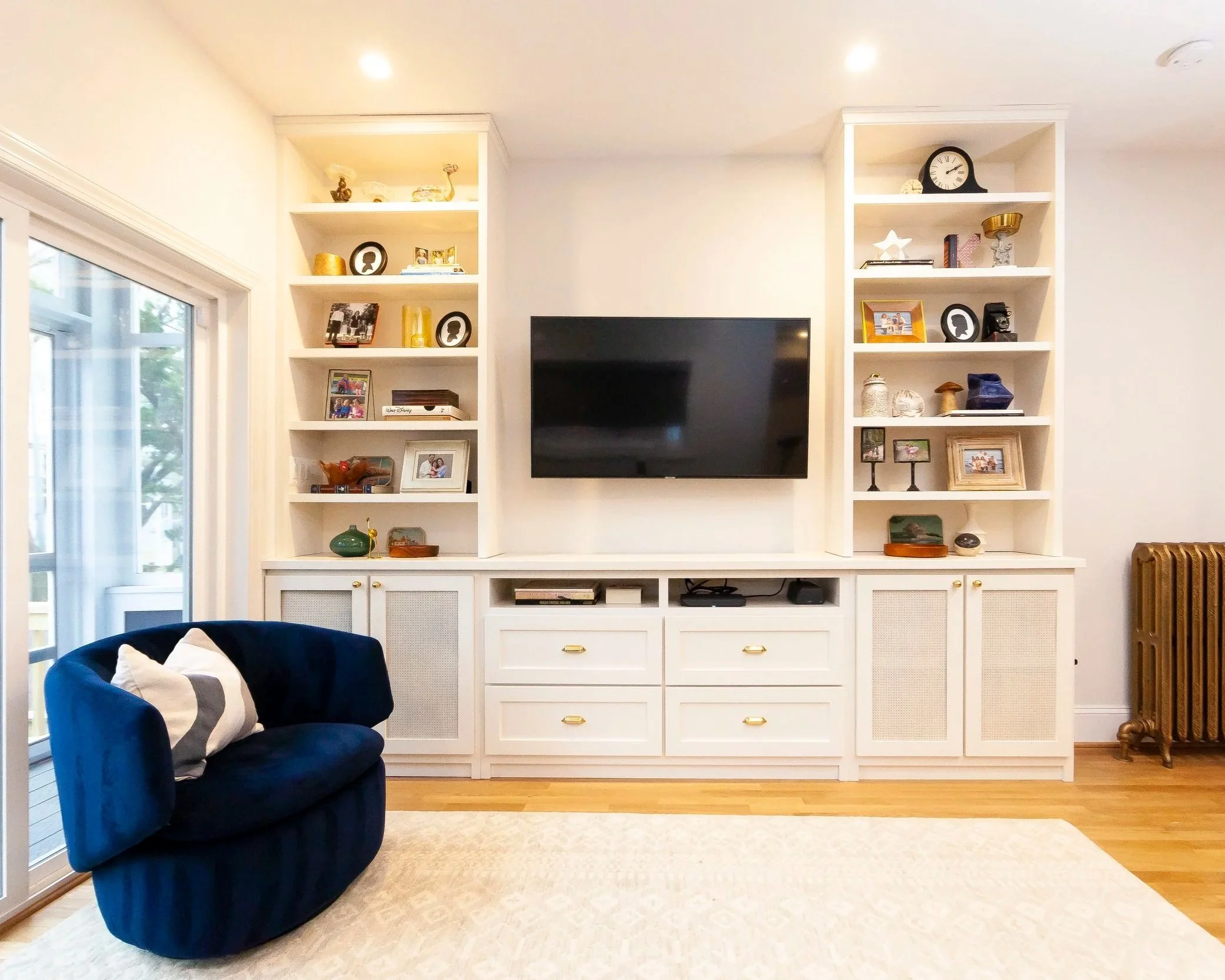 Open family room with navy swivel chair, mid-century furniture, and sliding glass doors, Washington DC interior design
