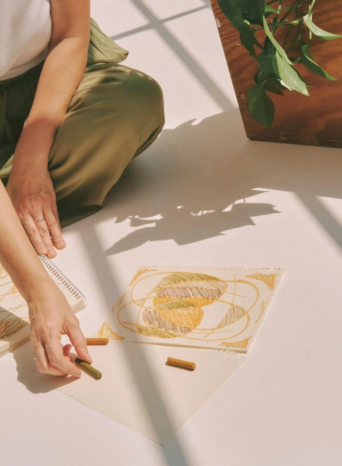 woman sitting on the floor with paper and colours.