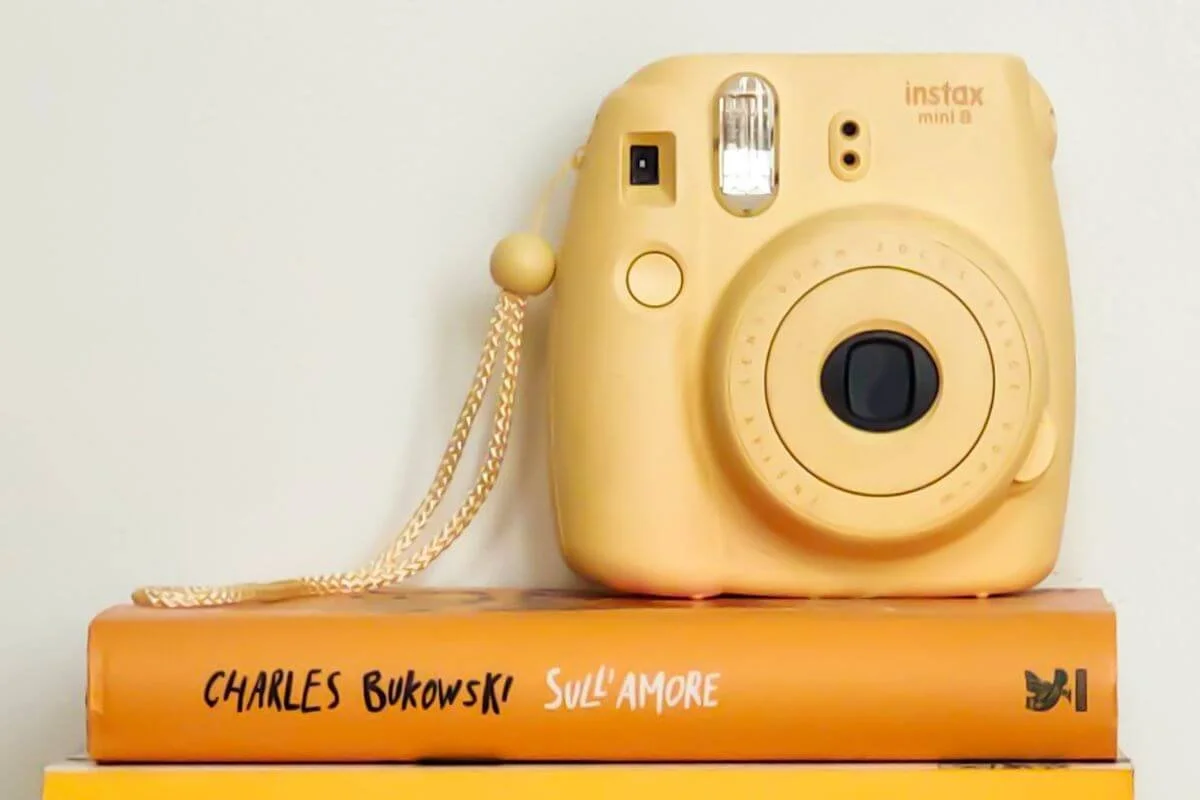 Yellow camera on book representing a love of photography