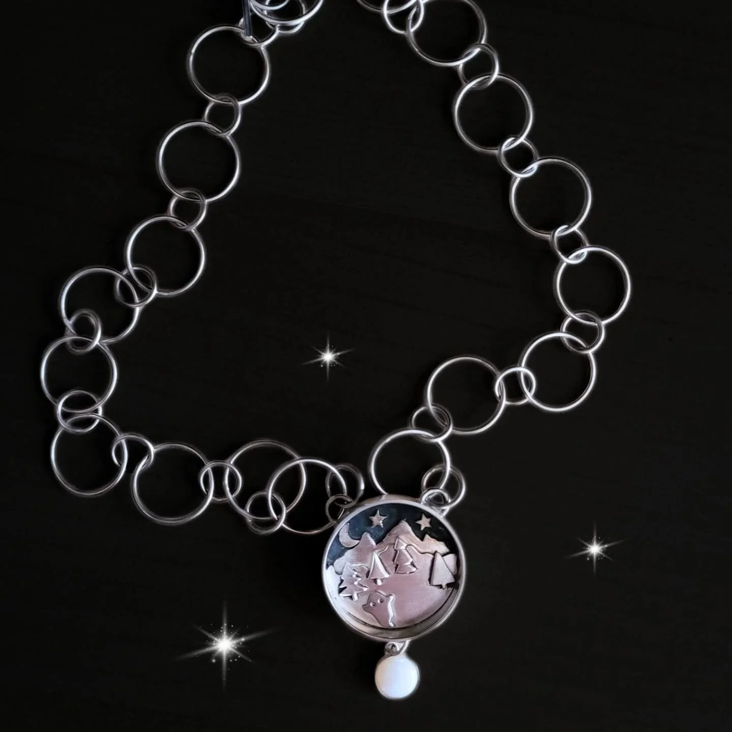 I made this piece a few years ago and thought I&rsquo;d share it here. It&rsquo;s a shadow box pendant featuring a dangling opal and a chunky sterling silver chain. Inside, you&rsquo;ll catch a glimpse of a nighttime scene with a mystical mountain ra