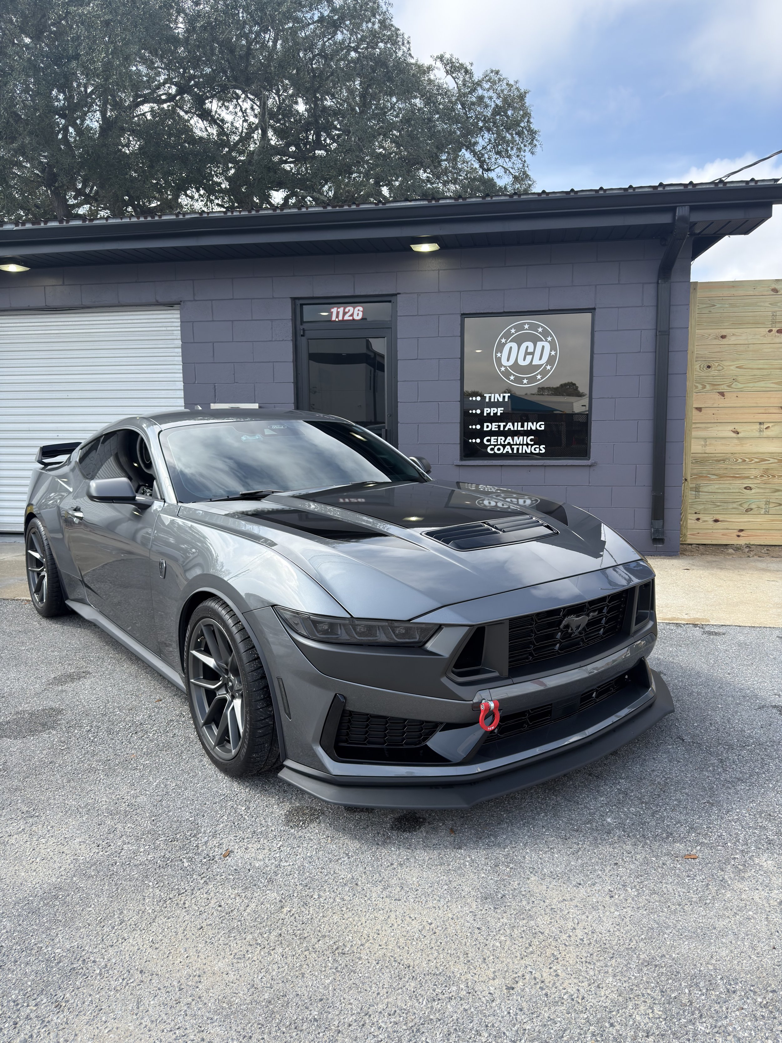 Car hood with a towel, a small container, and the text 'CERAMIC COATING' overlayed.