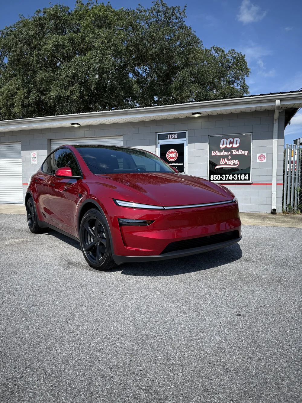 Red Tesla Model Y outside OCD in Fort Walton Beach