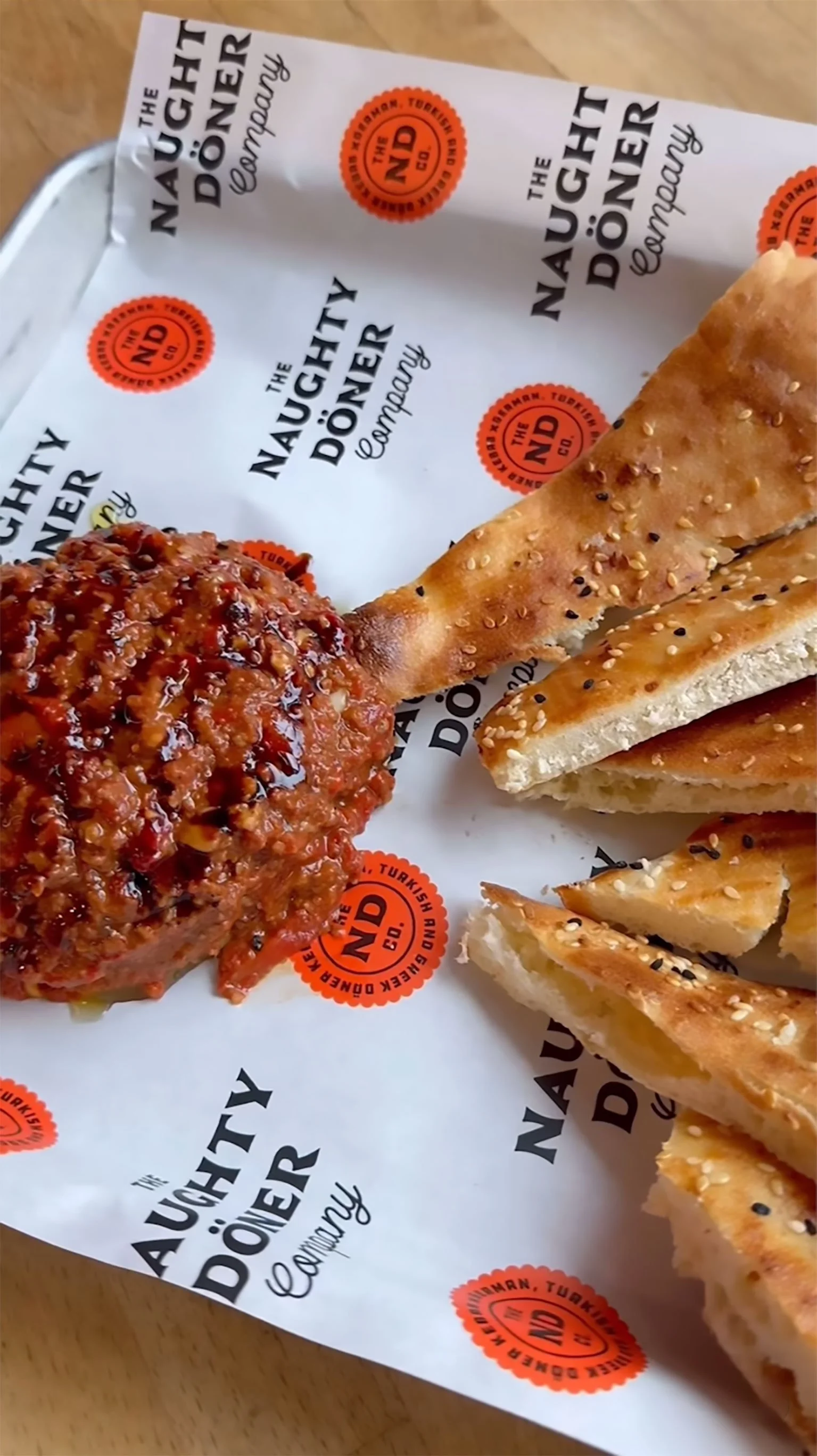 Photograph of The Naughty Doner Co. appetizer plater on branded paper ini a metal tray.