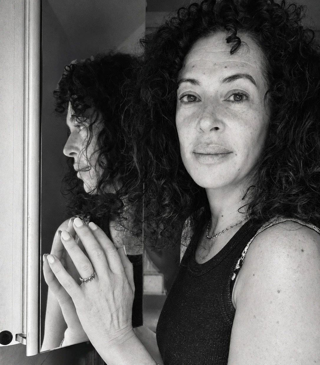 Mala Moonbeam touching her reflection during a Mirror Time Method ritual for midlife self-connection