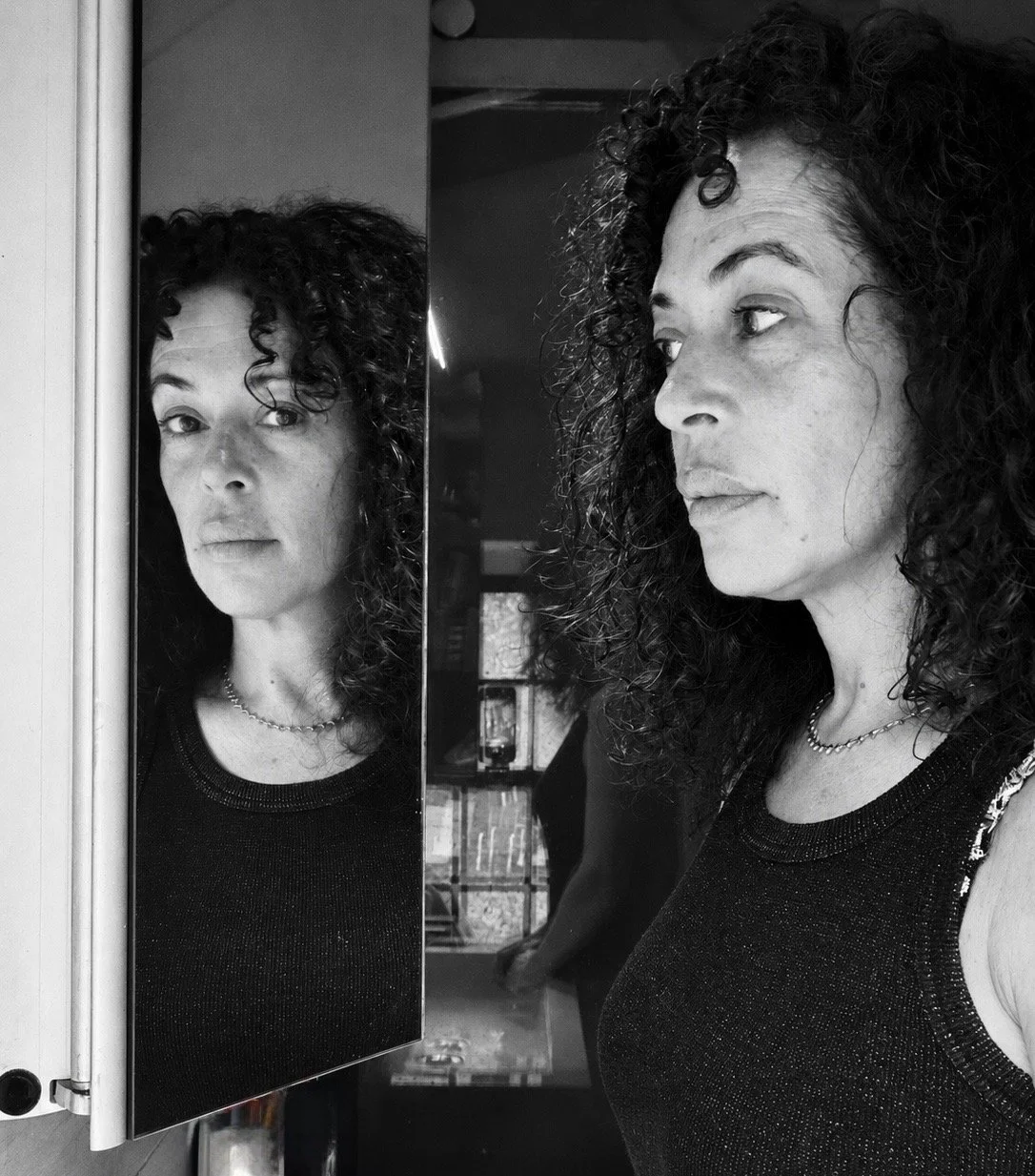 Mala Moonbeam and her reflection looking in different directions during a midlife mirror ritual