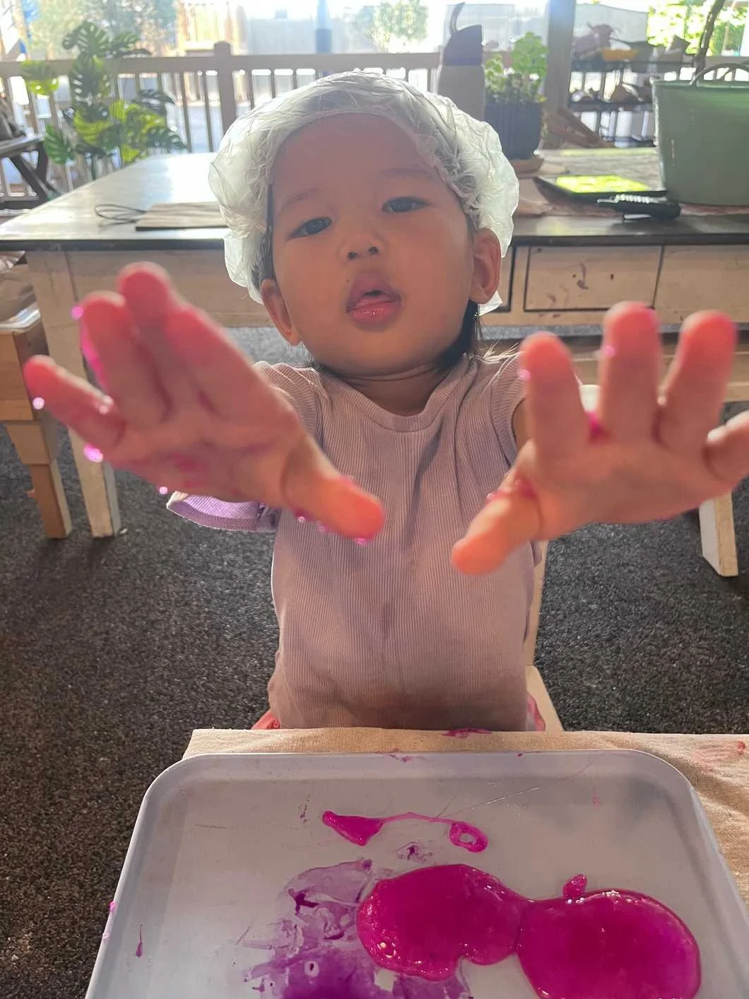 Child showing hands with slime.