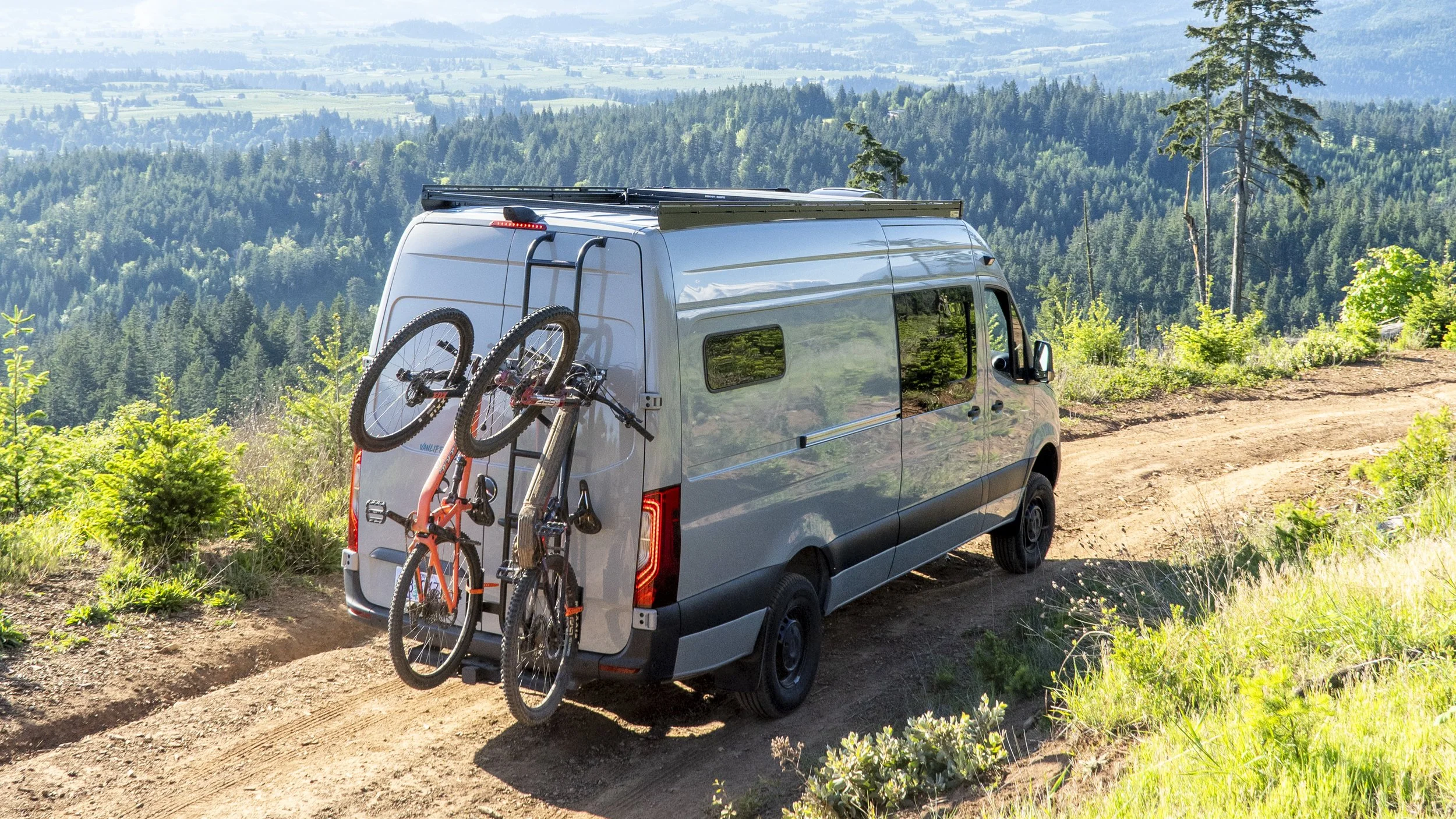 Extended Mercedes Sprinter van conversion on dirt road at Post Canyon, Hood River Oregon, with mountain bikes on rear rack