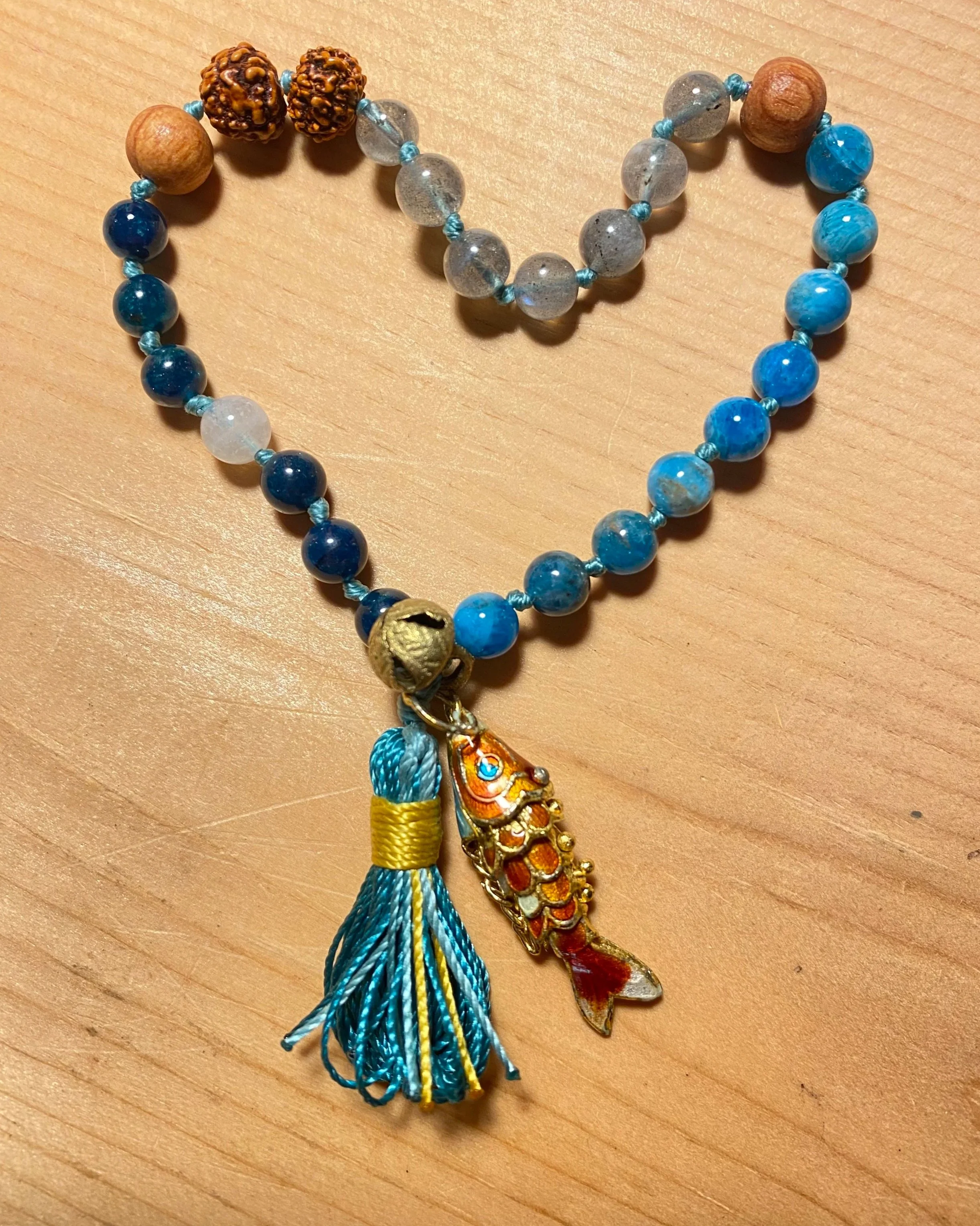 Quarter Mala (not for sale) apatite, tulsi, labradorite, rudraksha, dark blue apatite, moon stone, brass bell and segmented enameled fish. 