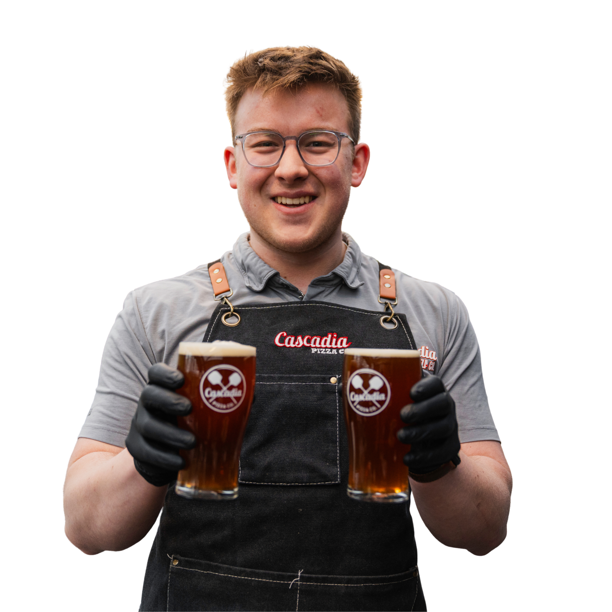Person wearing glasses and a Cascadia Pizza Company apron holding two glasses of beer.