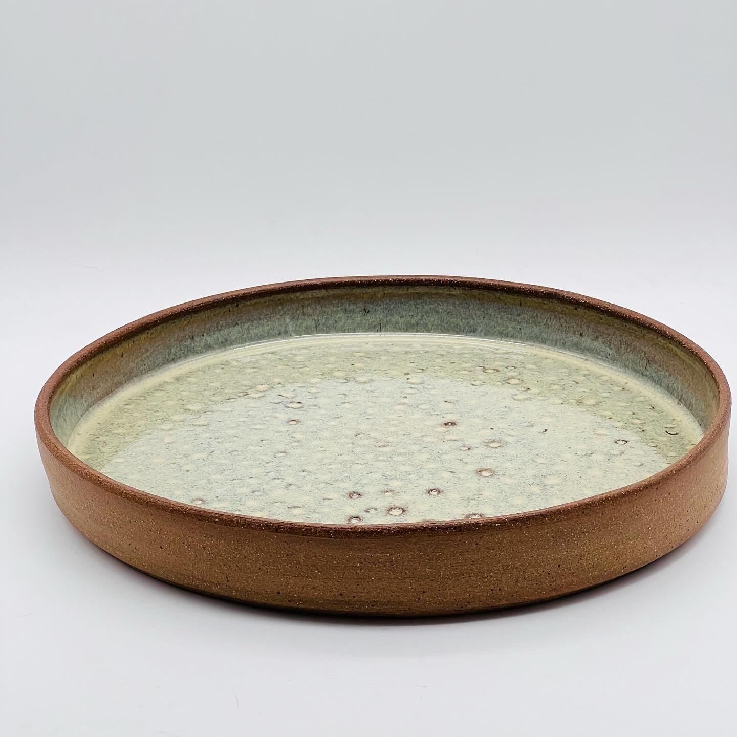 Is this a plate or a platter at 9.5&rdquo;d? However it will be used, it&rsquo;ll be great! The toasty exposed clay on the outside is a great contrast to the lichen-like glaze inside. 
.
.
.
#plate #platter #plattergoals #ceramicplatter #ceramicplate