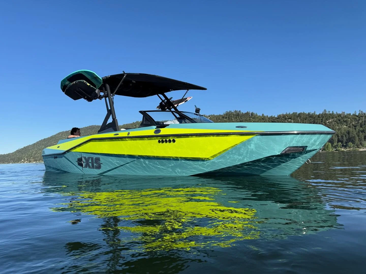 Blue and green Axis wake boat with Designated Wakesports on Big Bear Lake