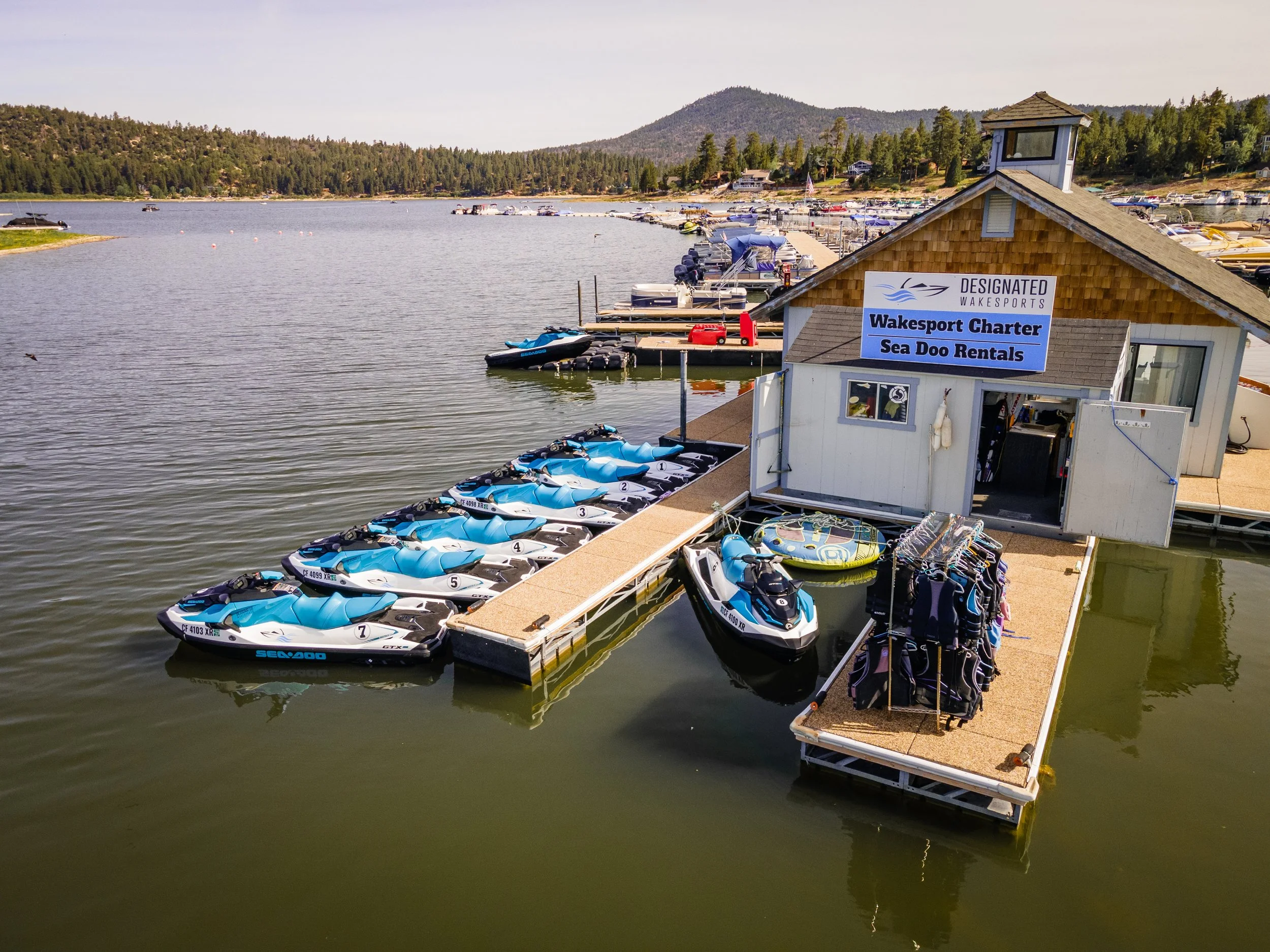 Blue Sea Doos lined up on a dock on Big Bear Lake with the mountains in the background