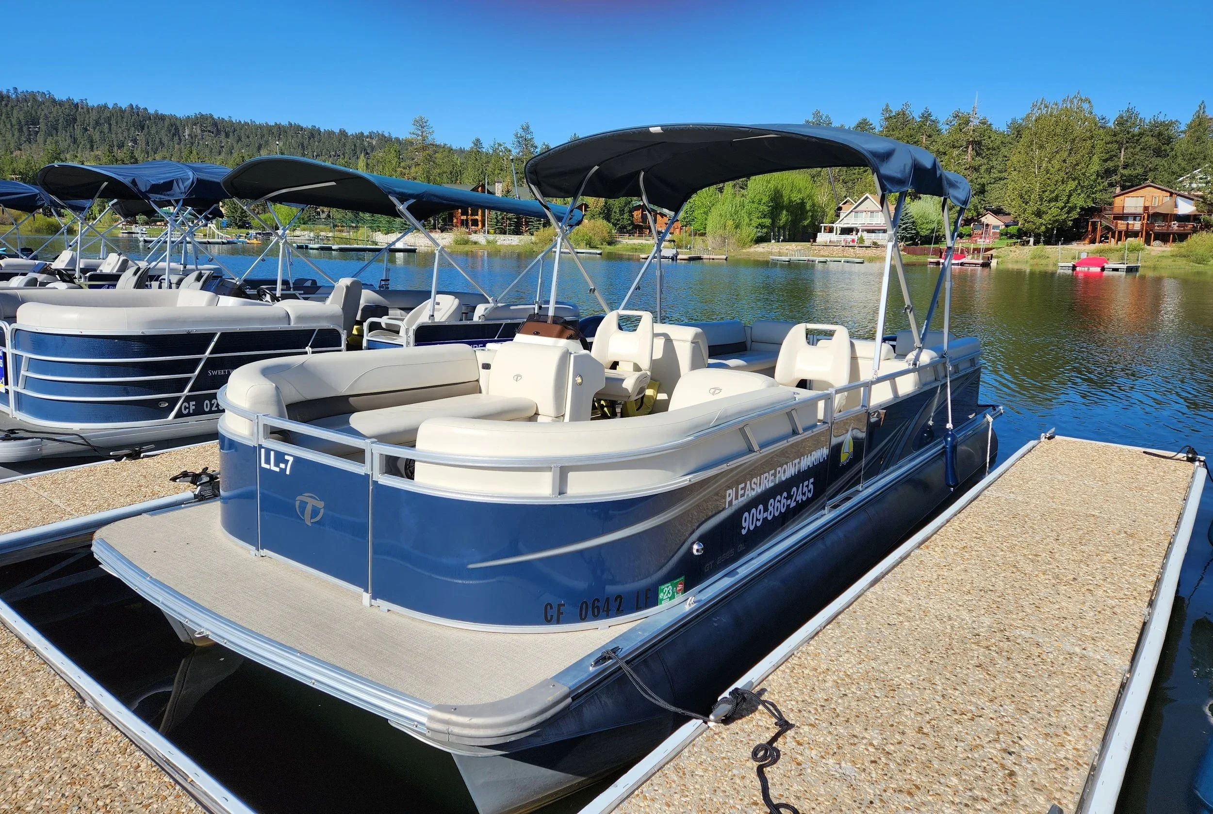 Blue sided, tan upholstery Tahoe pontoon boat on the pleasure point dock
