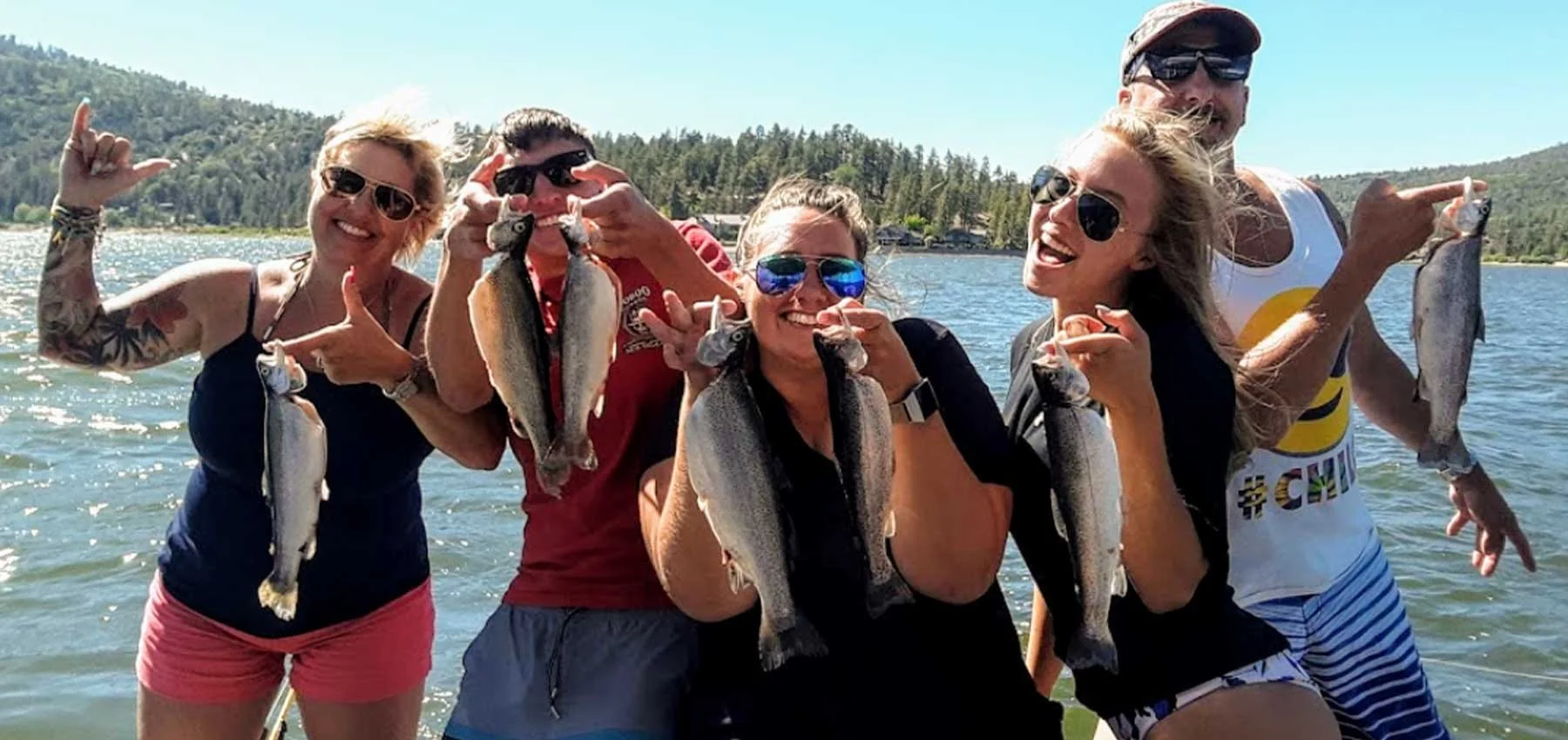 Five young people smiling with the fish they caught while on Big Bear Lake with Cantrell Fishing Guide Service