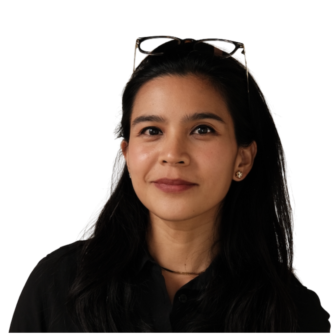 Close-up portrait of a young woman with black hair, wearing a black shirt, small earrings, and sunglasses on her head, smiling softly.