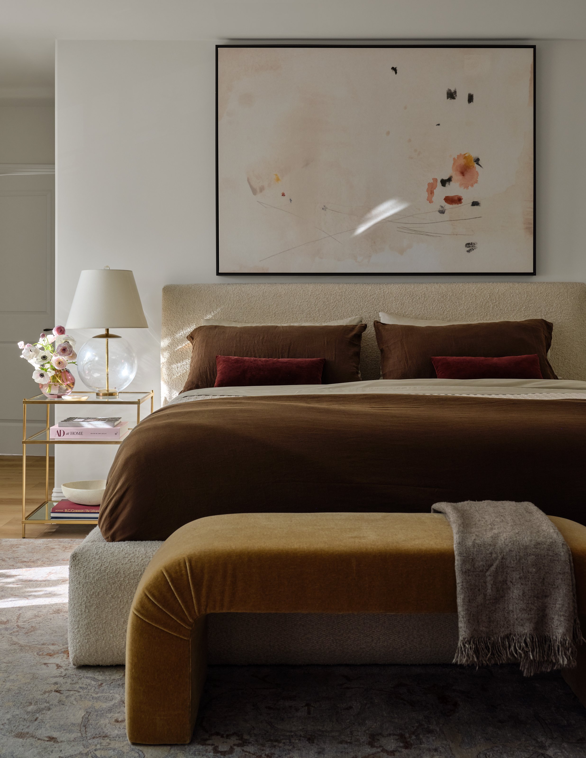 A serene primary bedroom layered in rich, earthy tones and soft texture. Chocolate linen, warm velvet, bouclé, and understated artwork come together to create an intimate retreat that feels luxurious, collected, and effortlessly comfortable.
